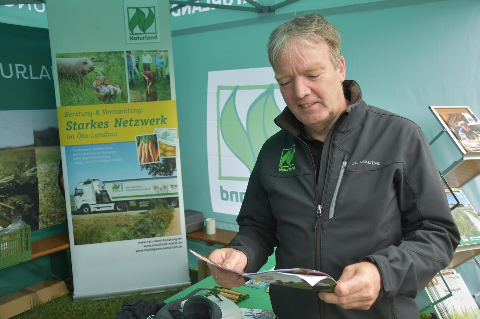 Naturland-Umstellungsberater Andreas Jessen blättert in einem Prospekt. 