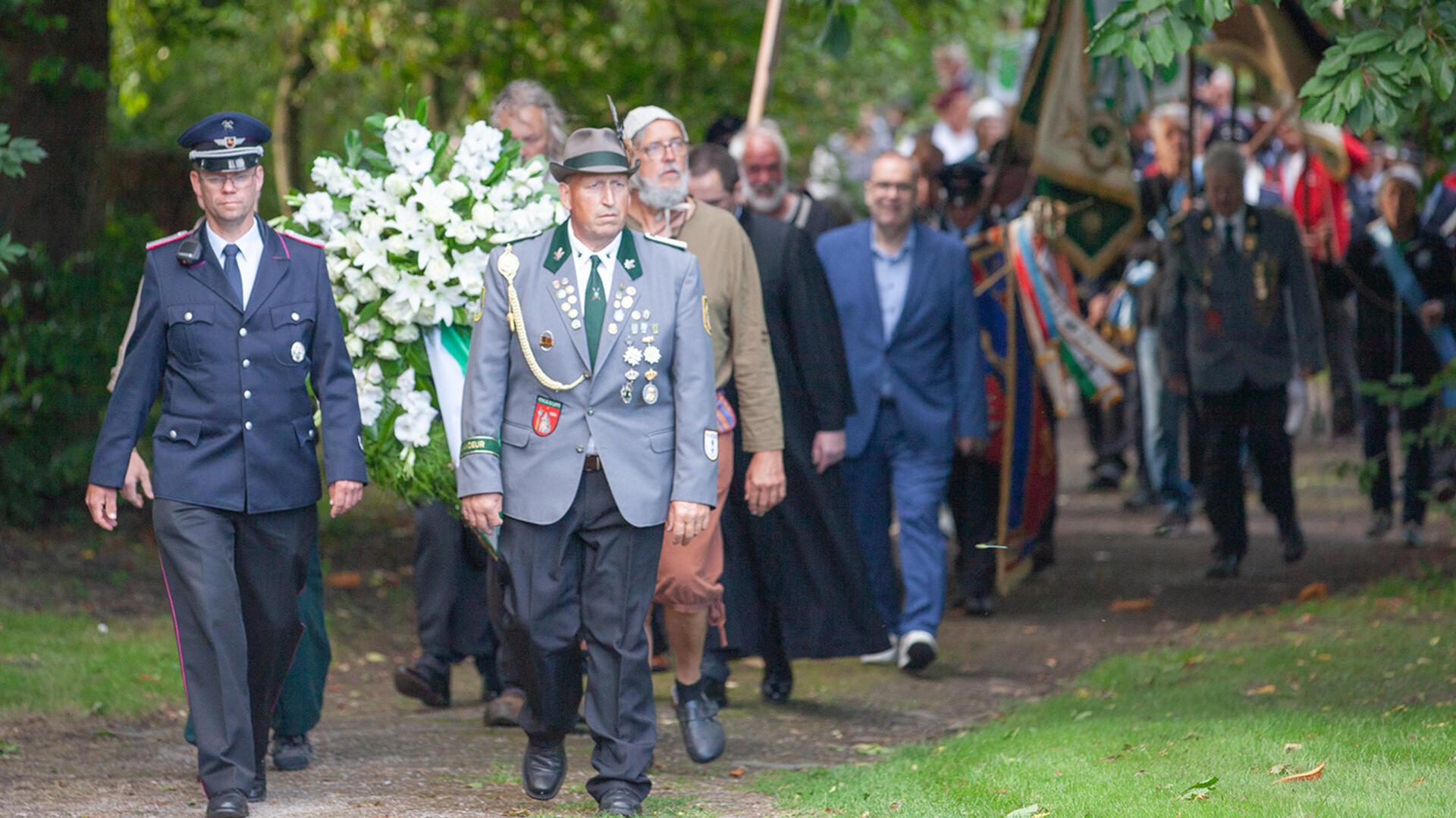 Neben zahlreichen Bewohnern der Gemeinde Wurster Nordseeküste nehmen auch Landesbischof Ralf Meister, Superintendent Albrecht Preisler und Landrat Thorsten Krüger am Gedenkmarsch mit Kranzniederlegung teil.