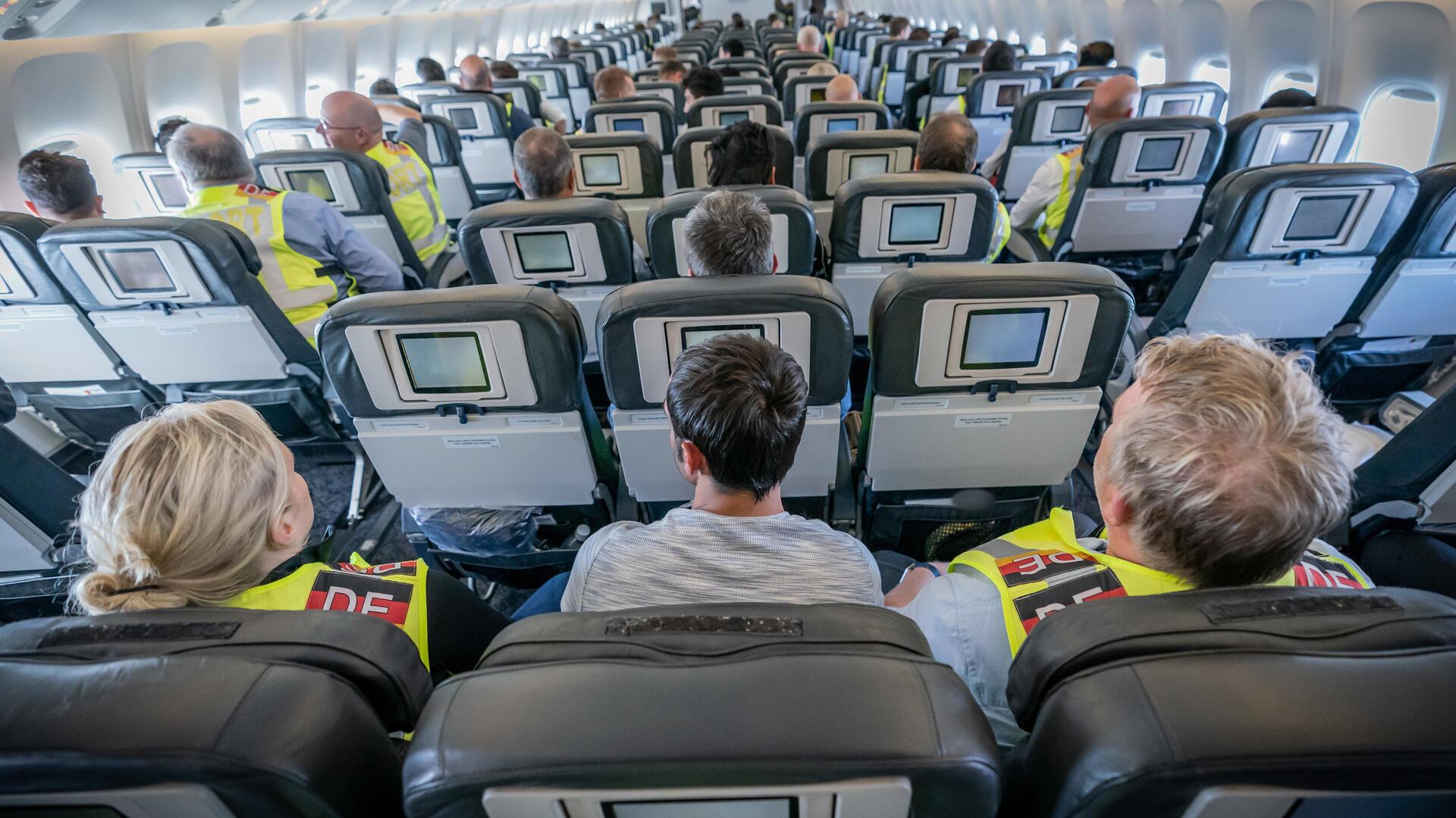 Sitzreihen mit Passagieren in einem Flugzeug