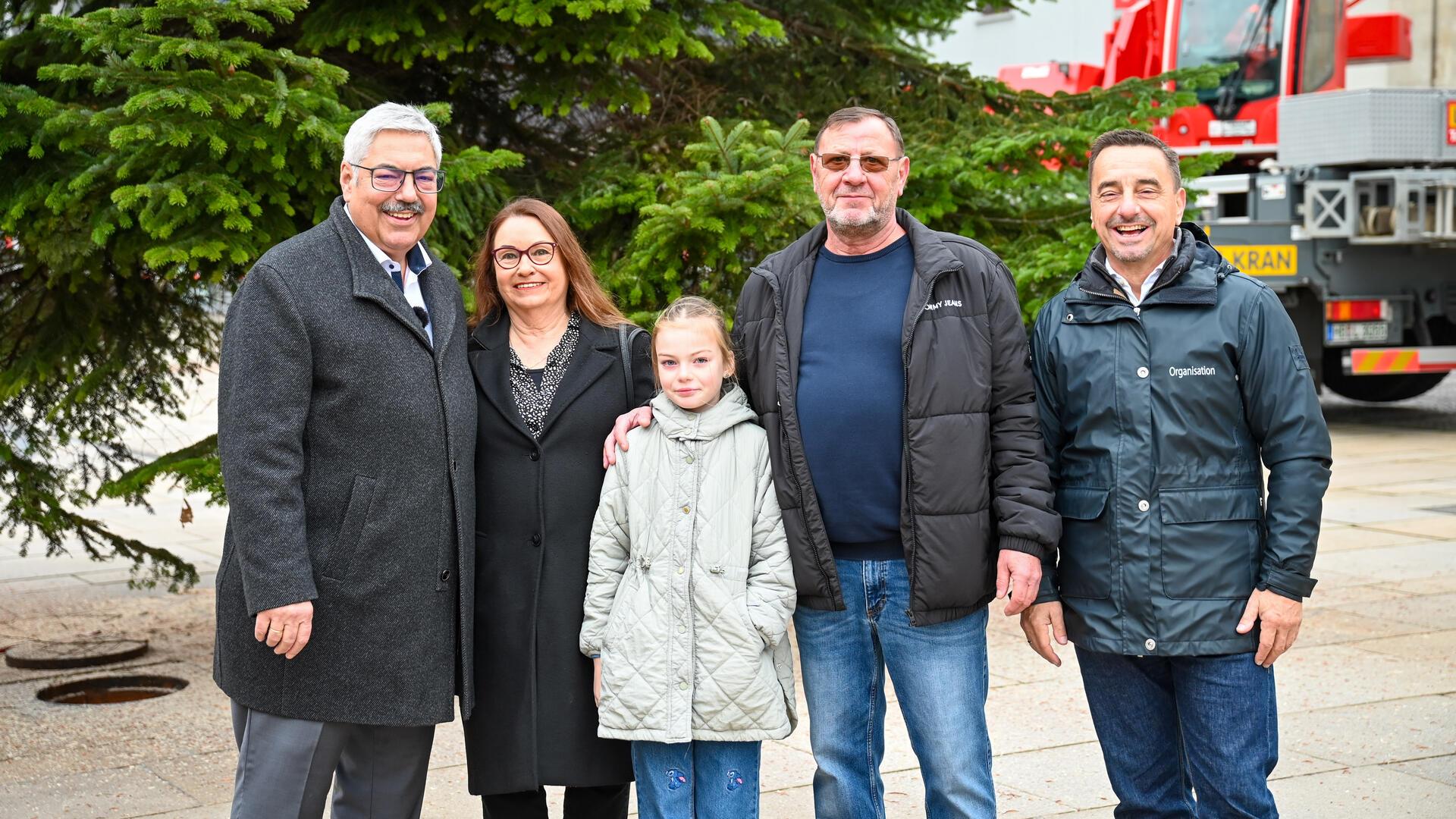 Oberbürgermeister Melf Grantz (SPD, ganz links) bedankt sich für die Spende bei Linda von Oesen, Dieter Güll und deren Enkelin Marie. Erlebnis-Chef Michael Gerber (rechts) lobt den diesjährigen Weihnachtsbaum.