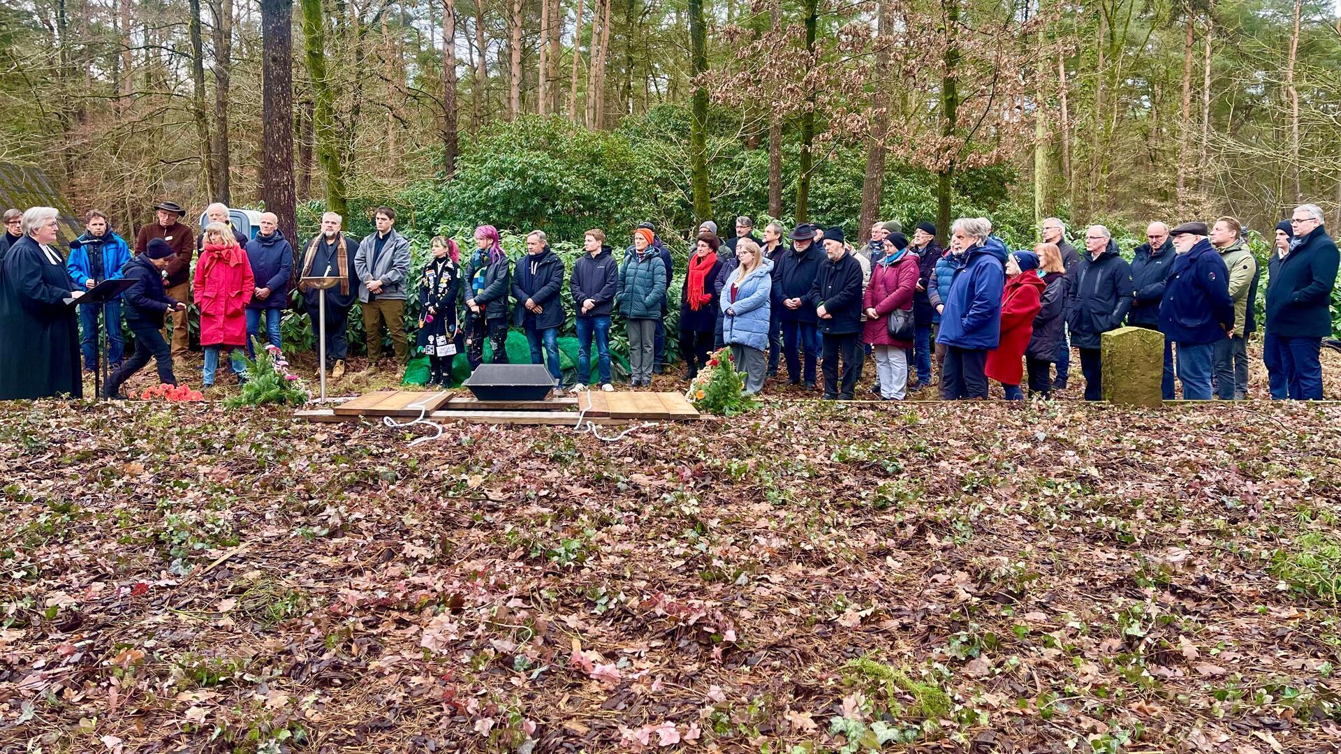 Pastorin Petra Lemmel (links) von der Selsinger St. Lamberti Kirchengemeinde bei der Wiedereinbettung eines unbekannten sowjetischen Gefangenen auf der Kriegsgräberstätte in Sandbostel.