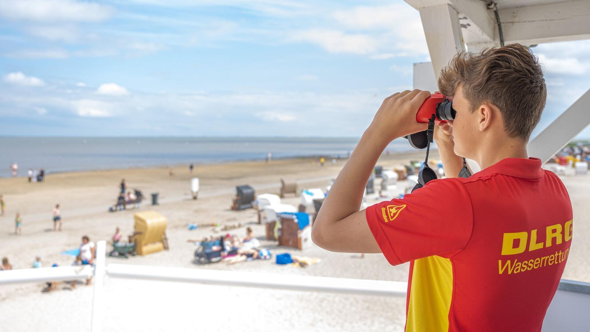 Peter von der DLRG-Wasserrettung steht auf einem Turm am Badestrand von Dangast.