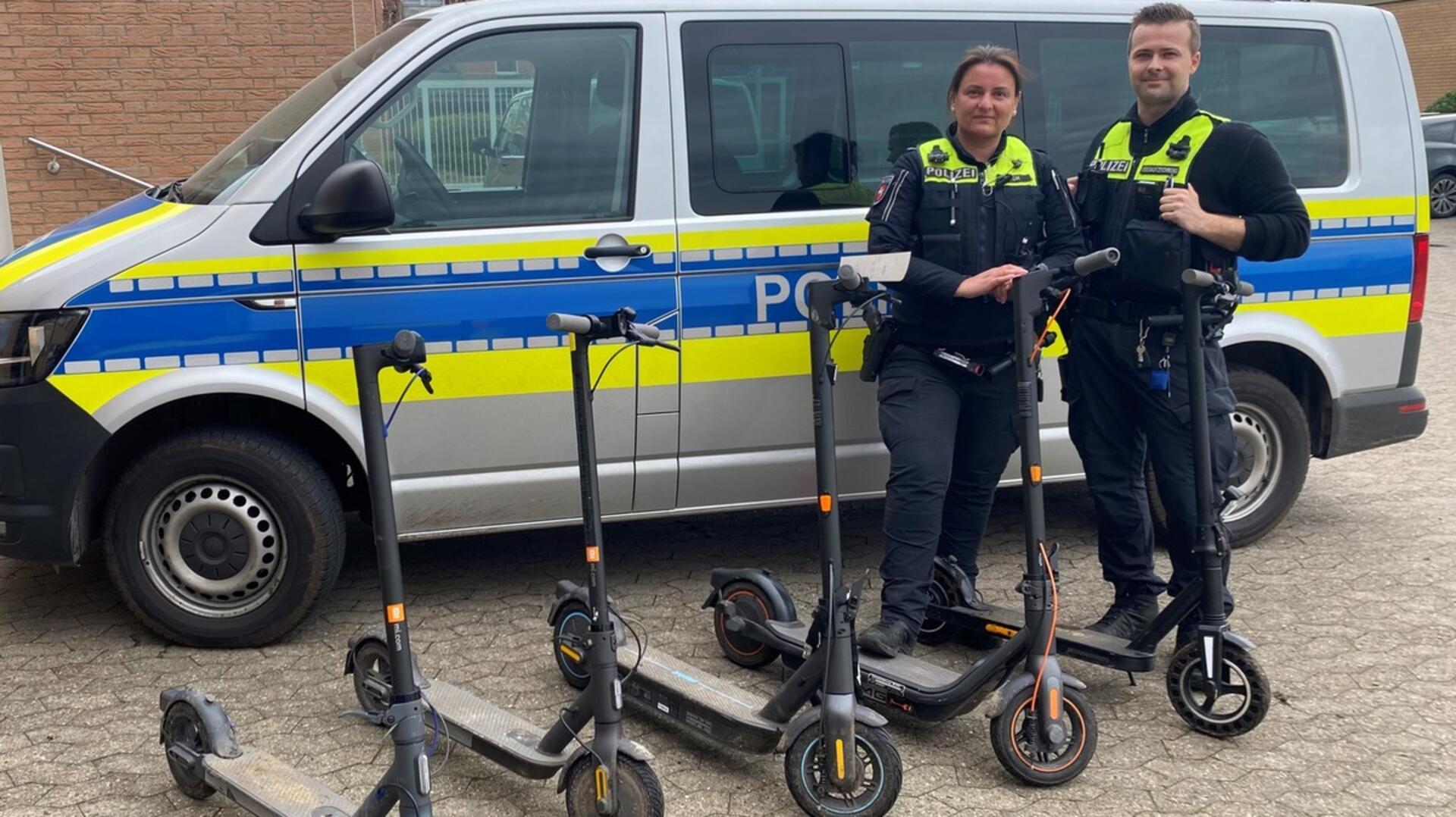 Polizisten präsentieren die sichergestellten, mutmaßlich geklauten E-Scooter.