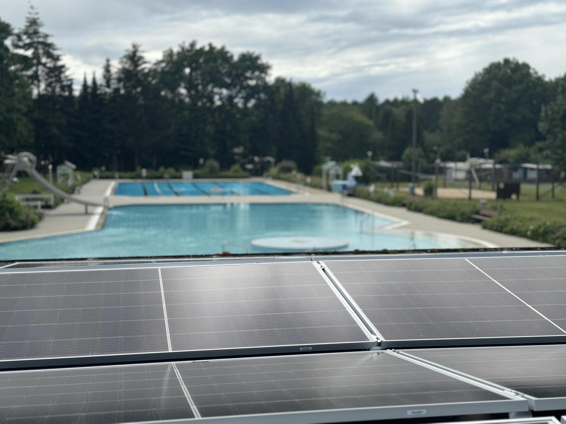 Eine PV-Anlage ist auf dem Dach eines Schwimmbadbegäudes.