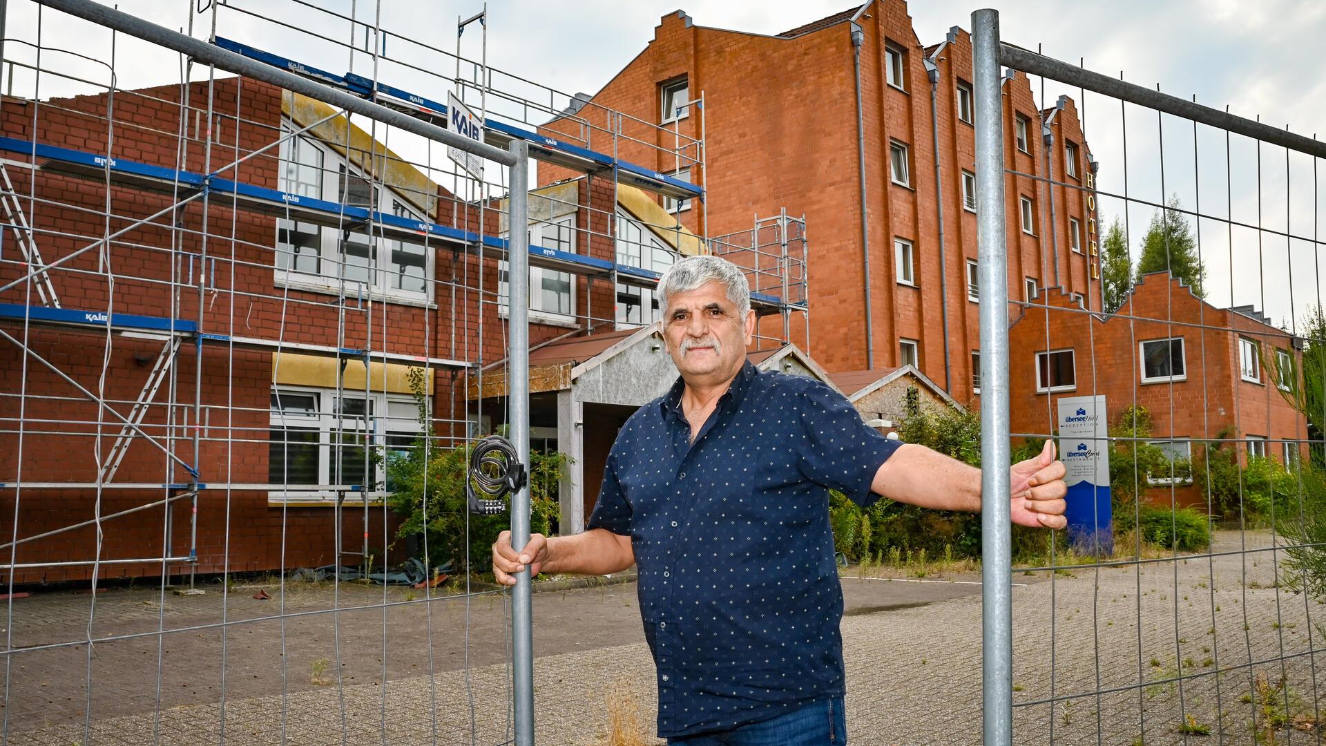 Ein älterer Mann zwischen zwei Bauzäunen.