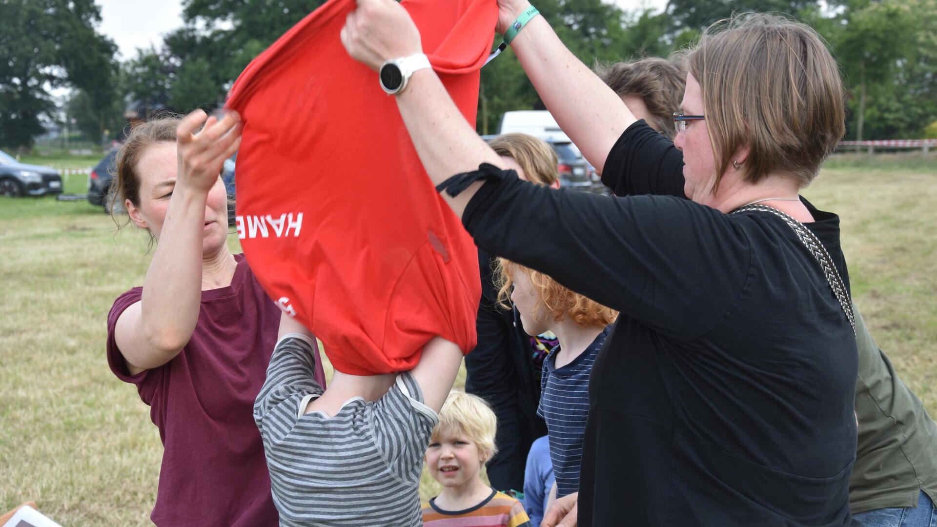 Das Foto zeigt eine Familie beim T-Shirt-Spiel. 