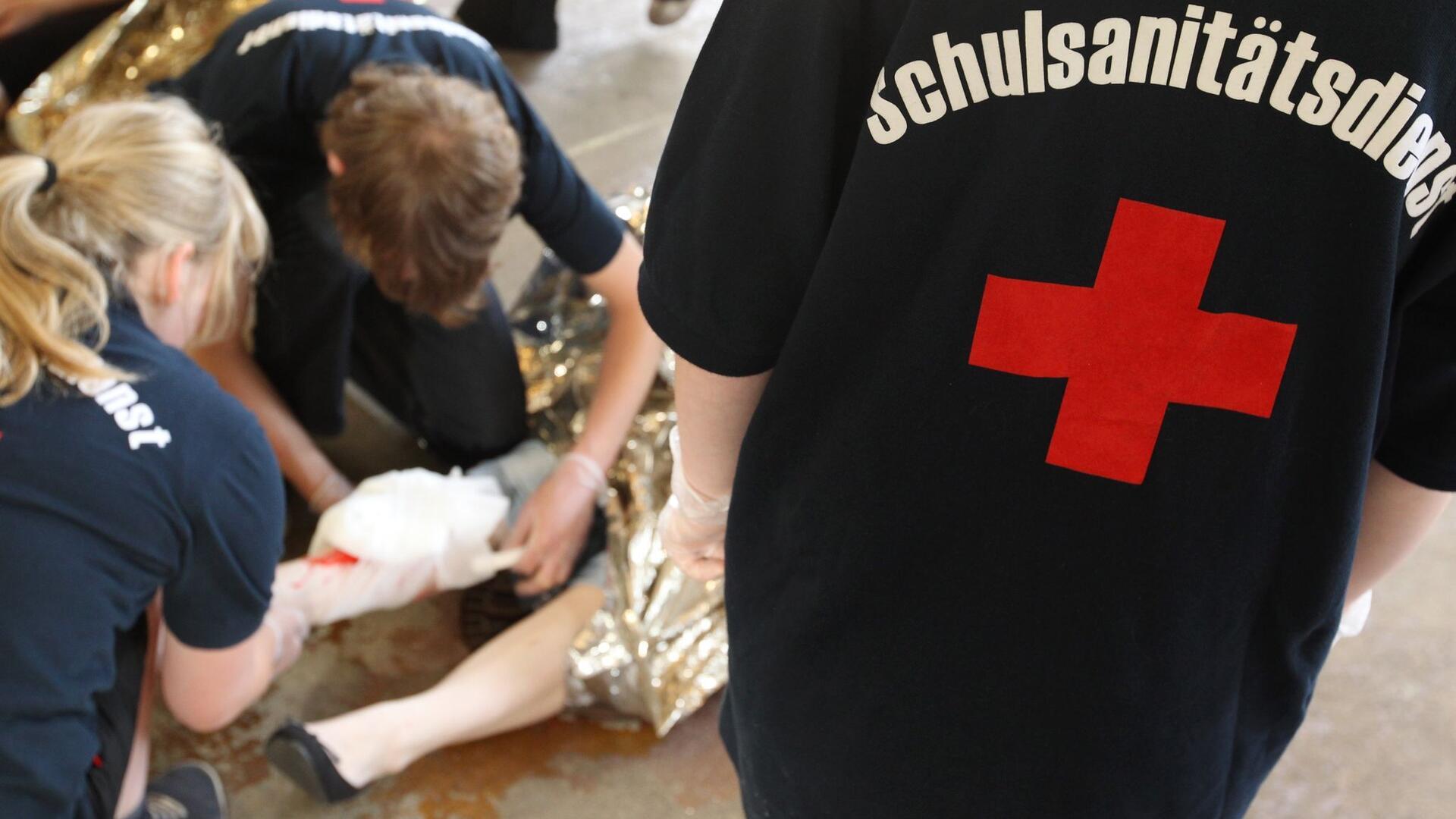 Schüler leisten in einer gestellten Situation Erste Hilfe.