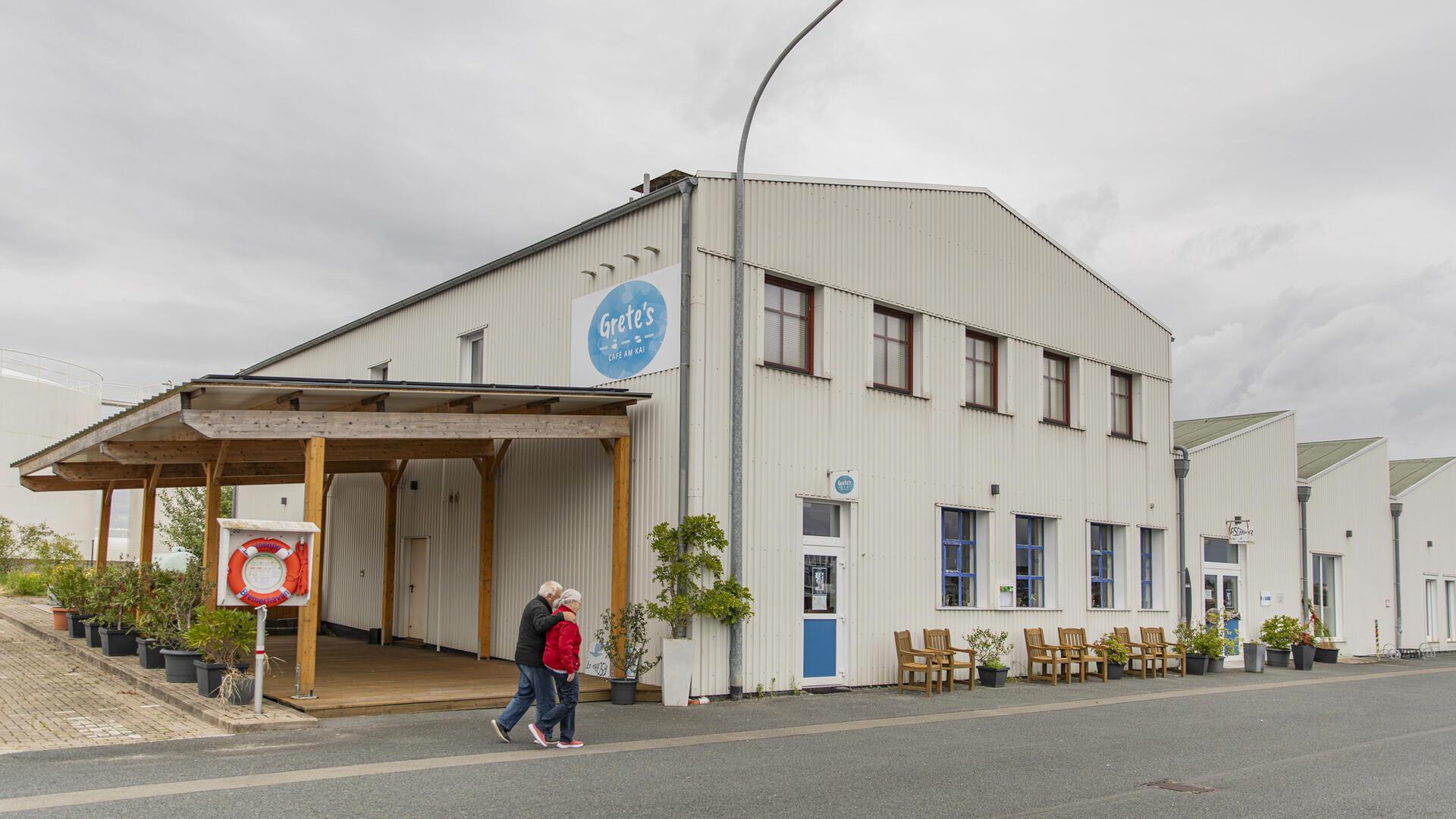 Eine alte Industriehalle, jetzt ein Café: Davor laufen Spaziergänger.