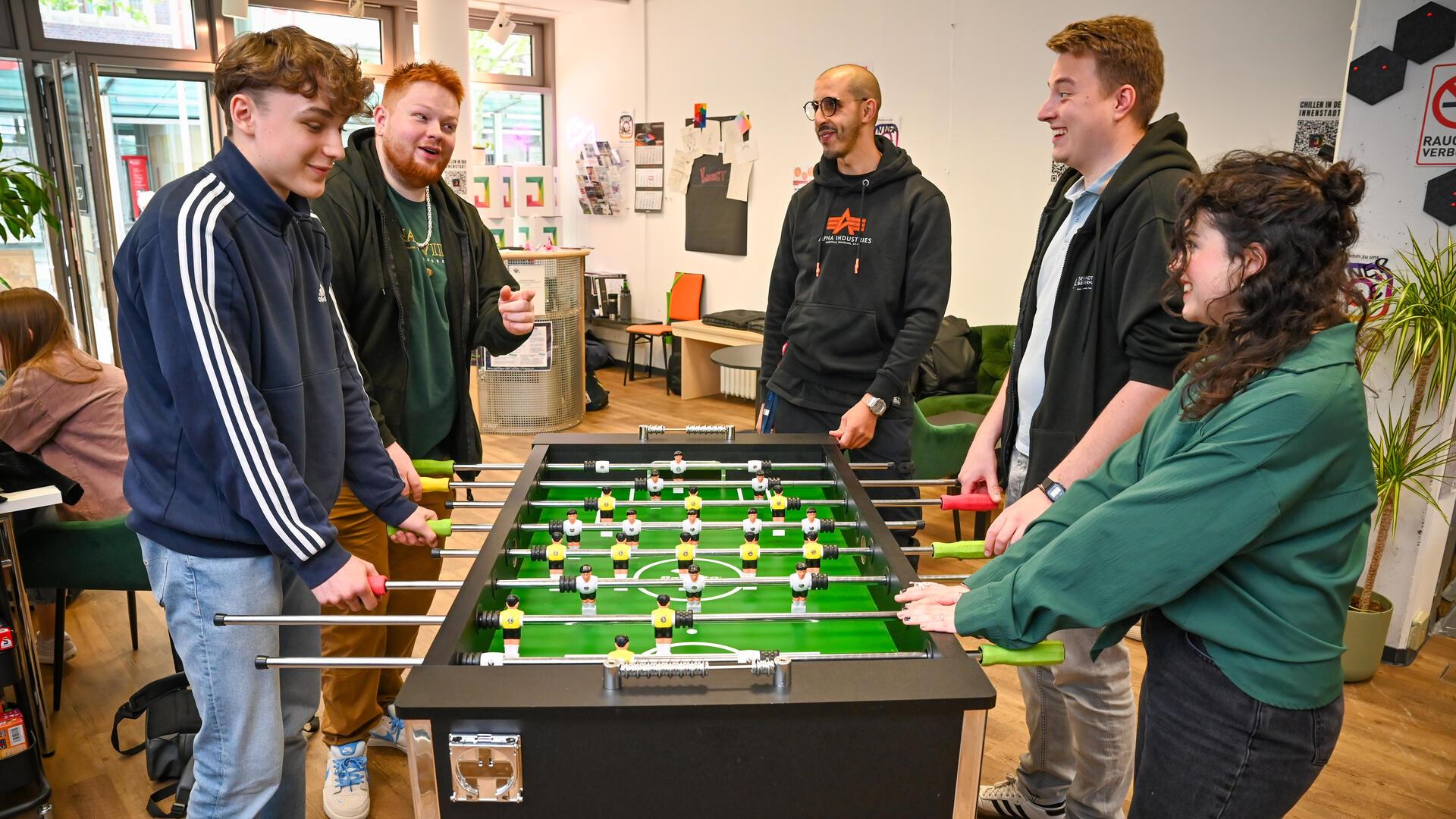 Junge Menschen spielen am Kickertisch im neuen Jugendraum in der Innenstadt in Bremerhaven. 