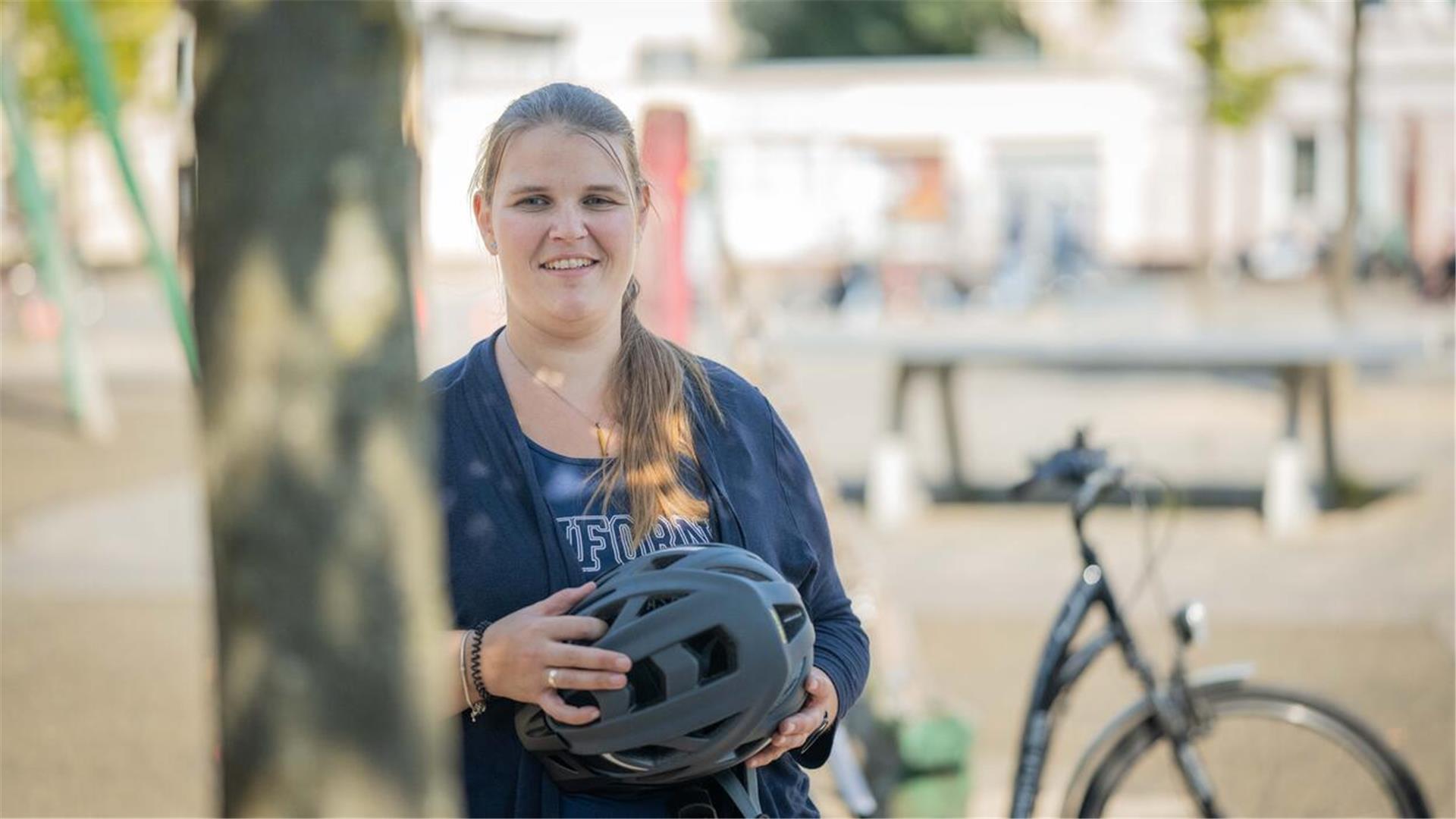 Frau mit Fahrradhelm in der Hand