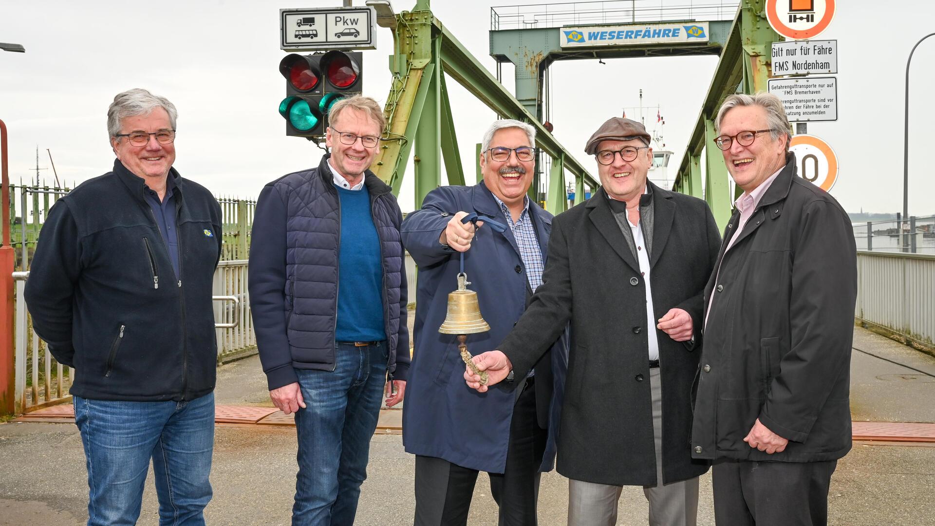 Sie sind erleichtert, dass die Weserfähre-Anleger-Sanierung pünktlich fertig ist und hängen es an „die große Glocke“: (von links) Jörg Stelter (leitender Ingenieur), Nordenhams Fähr-Geschäftsführer Hajo Schuchmann, Bremerhavens Oberbürgermeister Melf Grantz, Nordenhams Vize-Bürgermeister Bert Freese und Bremerhavens Fähr-Chef Robert Haase