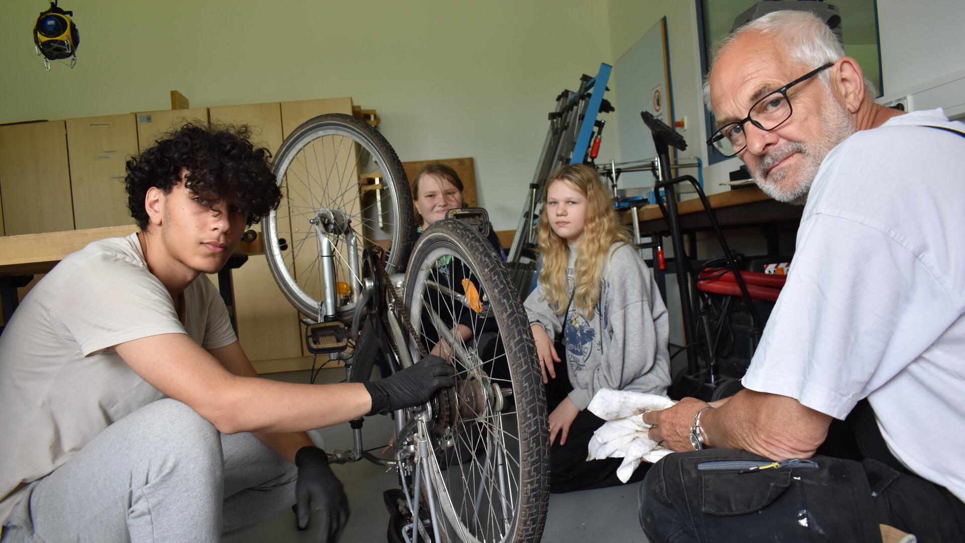 Schüler lernen, das Rad zu reparieren.