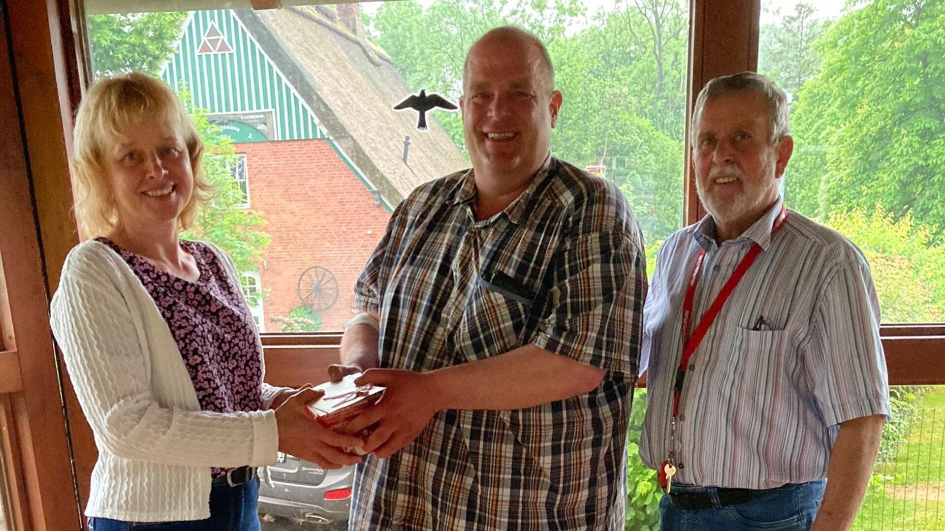 Sigrid Wettwer (links), die neue Leiterin des Sieverner Teams, übergibt an Mehrfachspender Martin Hey ein Präsent. Der bisherige langjährige Leiter, Hans Joachim Schweckendiek (rechts), freut sich, eine kompetente Nachfolgerin gefunden zu haben.