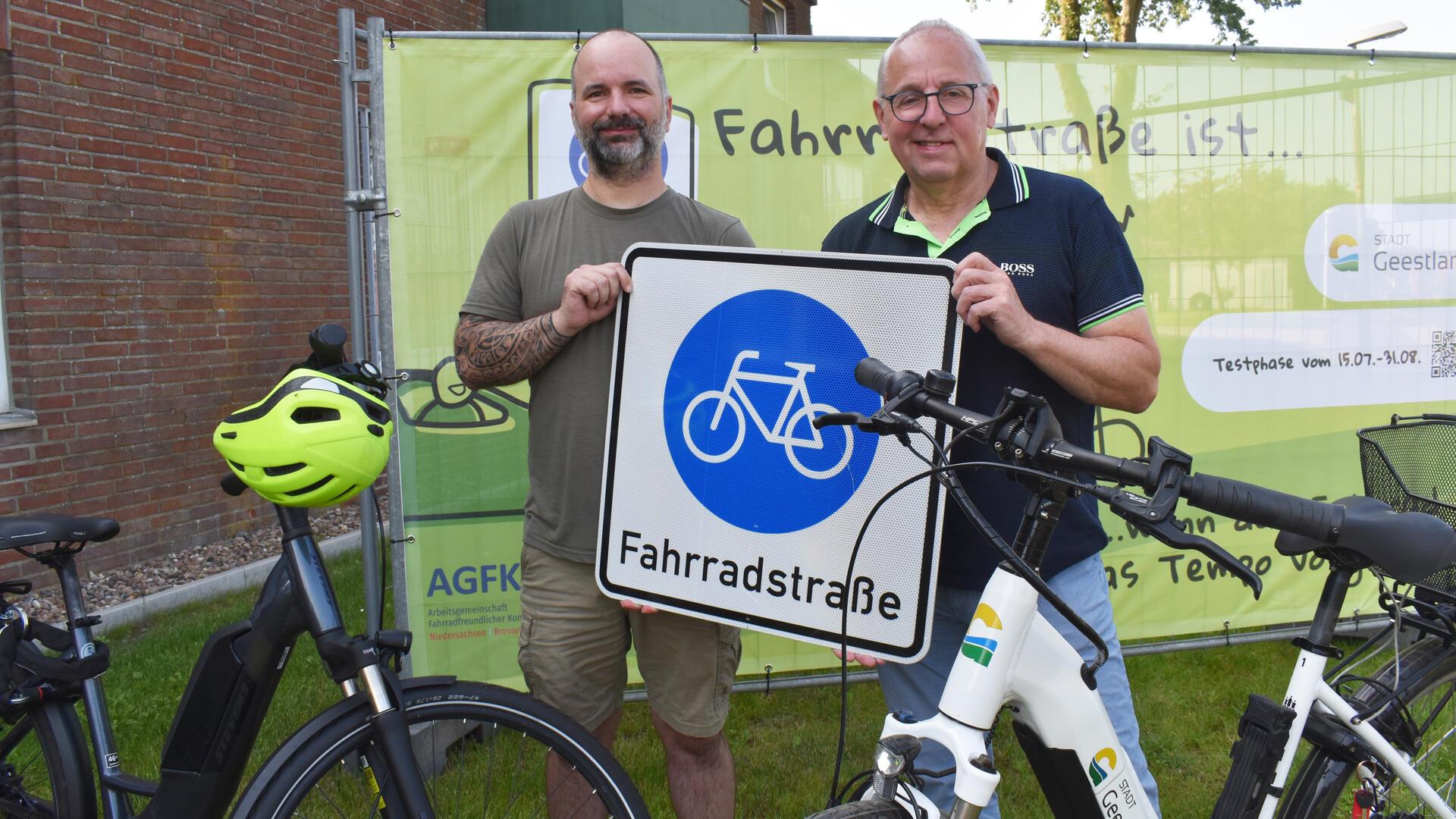 Zwei Männer halten ein Verkehrszeichen hoch