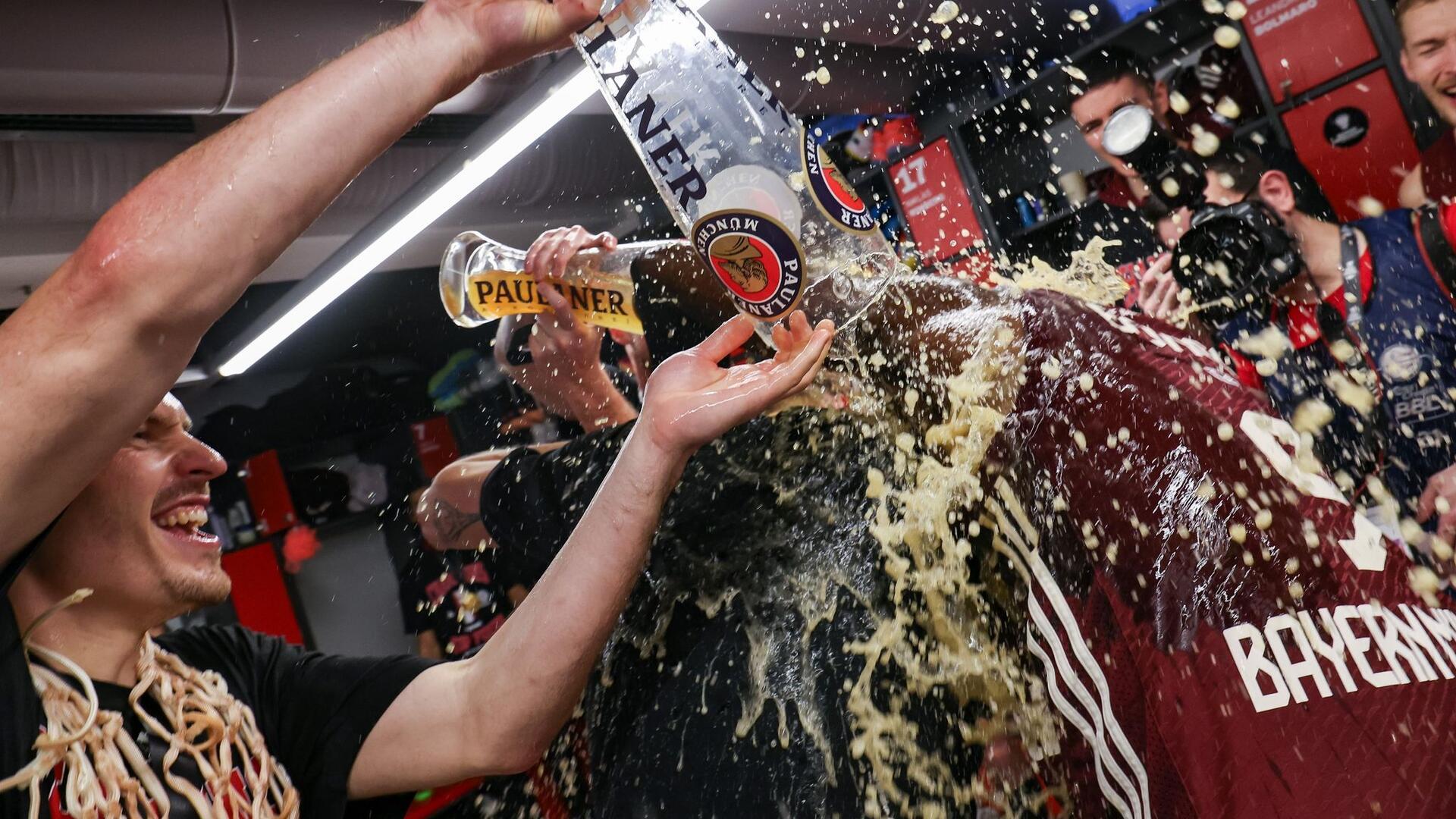 So begossen sehen Sieger aus: Der FC Bayern Basketball gewinnt im Finale gegen ratiopharm Ulm und wird Pokalsieger. Um den Jubel in der Kabine rauszulassen, braucht es aber anstelle des Pokals gut gefüllte Weißbiergläser.