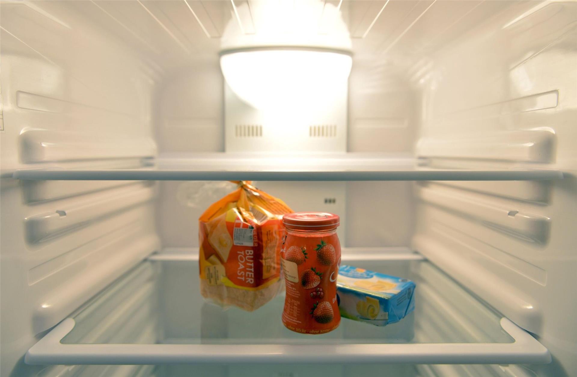 Konfitüre, Toastbrot und Butter stehen in einem Kühlschrank eines Einpersonenhaushalts. 