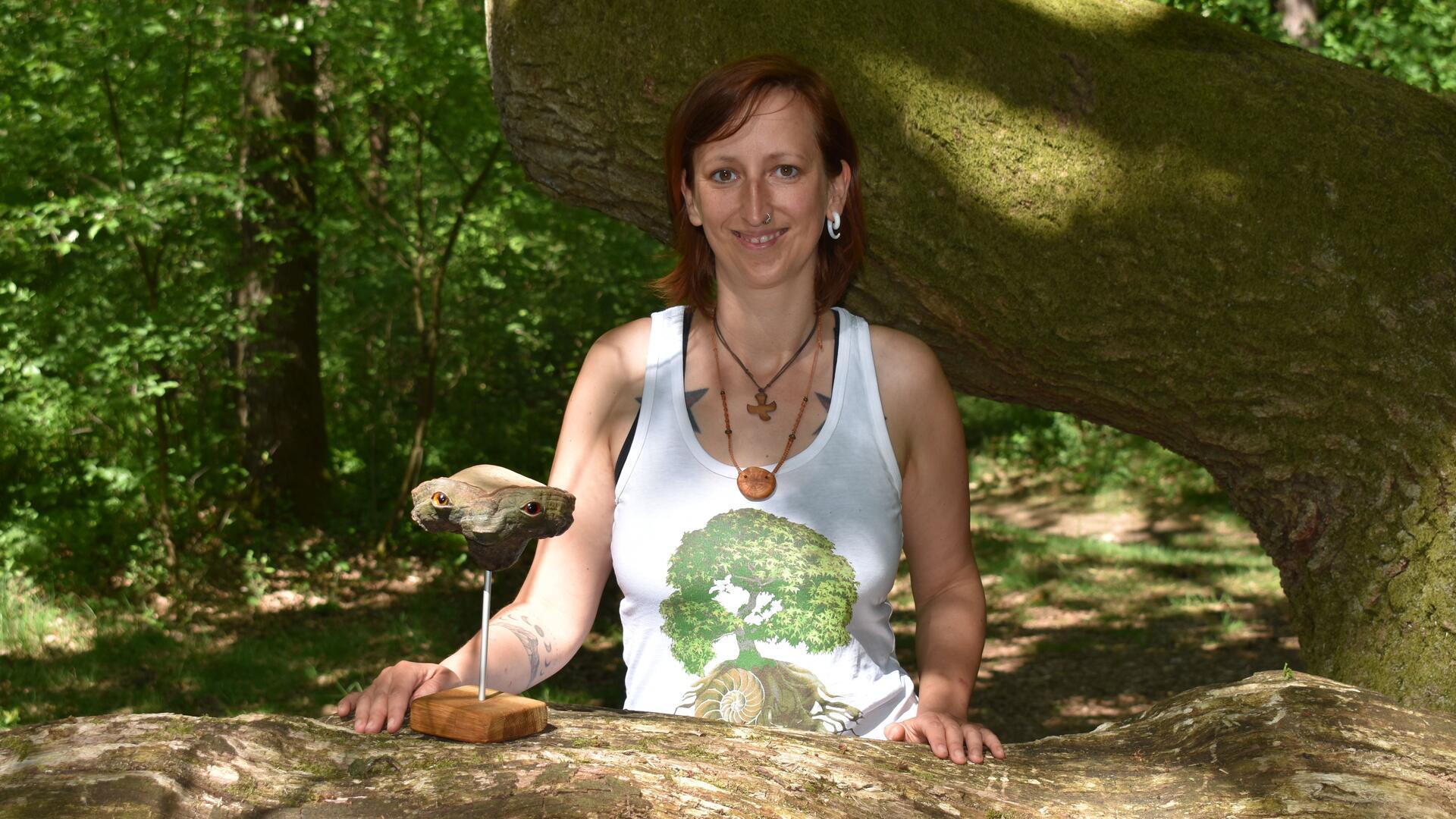 Frau mit weißem Hemd vor einem Baum