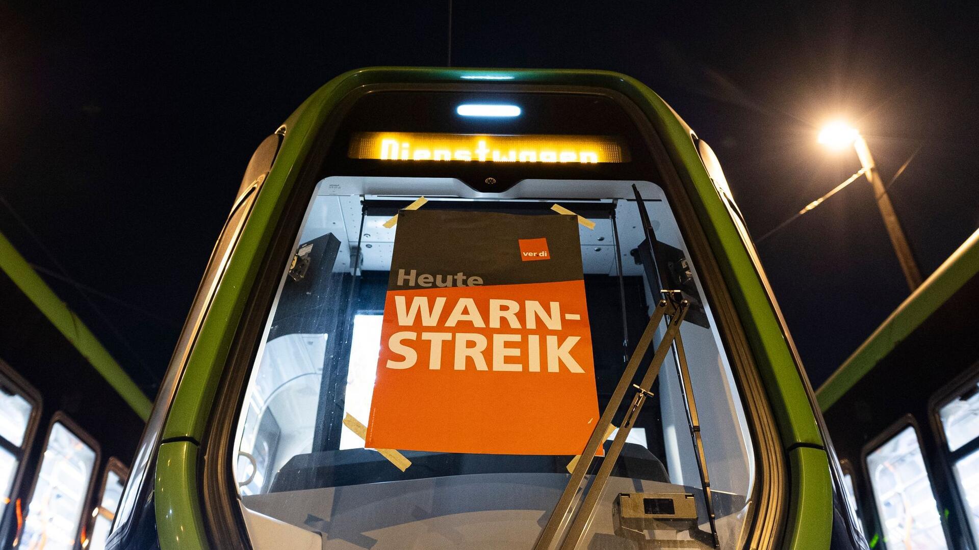 Stadtbahnen der hannoverschen Verkehrsbetriebe Üstra stehen auf dem Betriebshof Glocksee - auf einem Schild ist der Schriftzug „Heute Warnstreik“ zu lesen.