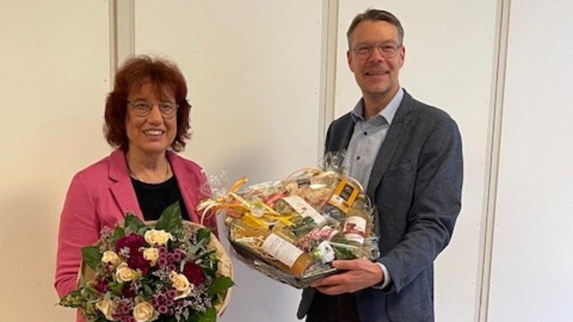 Stadtdirektor Henning Fricke verabschiedet Elke Seifert mit einem Präsentkorb und einem Blumenstrauß. ,