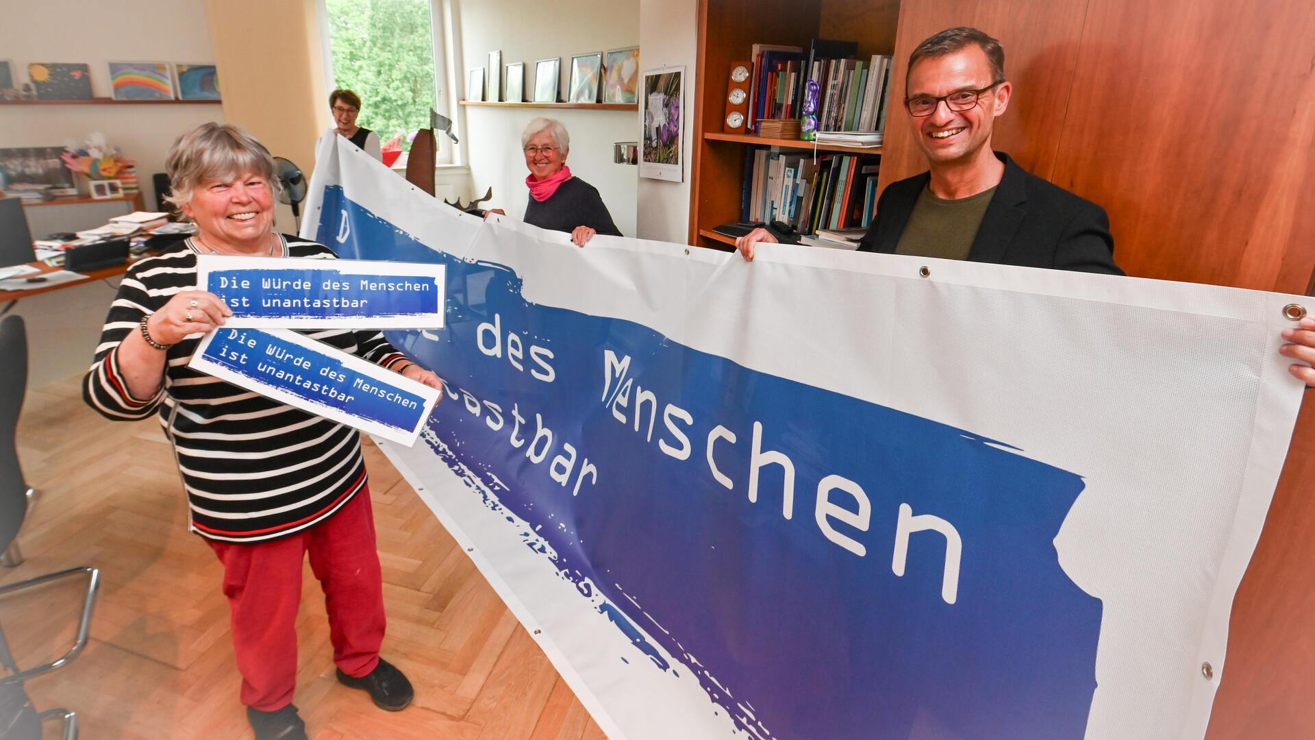 Stadtrat Michael Frost, die Kulturamtsleiterin Dorothee Starke, die Initiatorinnen der Kundgebung Gertrud Wiehler (2. v. re.) und Jutta Schmidt (li.) stellen ihre Kooperation und ein Plakat dazu vor.