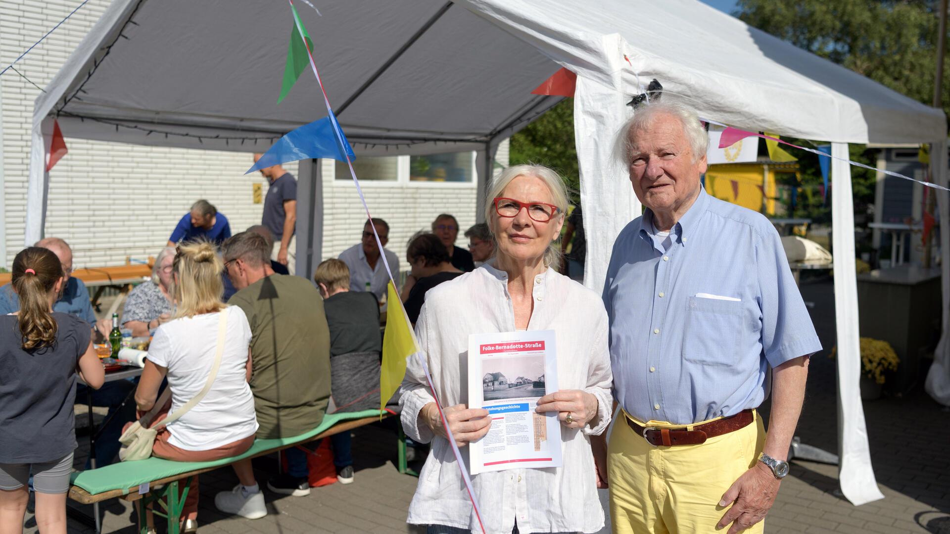 Zwei Menschen vor einem Festzelt.