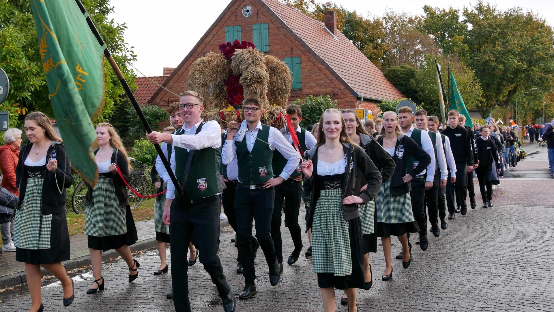 Stolz führt die Landjugend den Umzug an und trägt die Erntekrone durch das ganze Dorf.