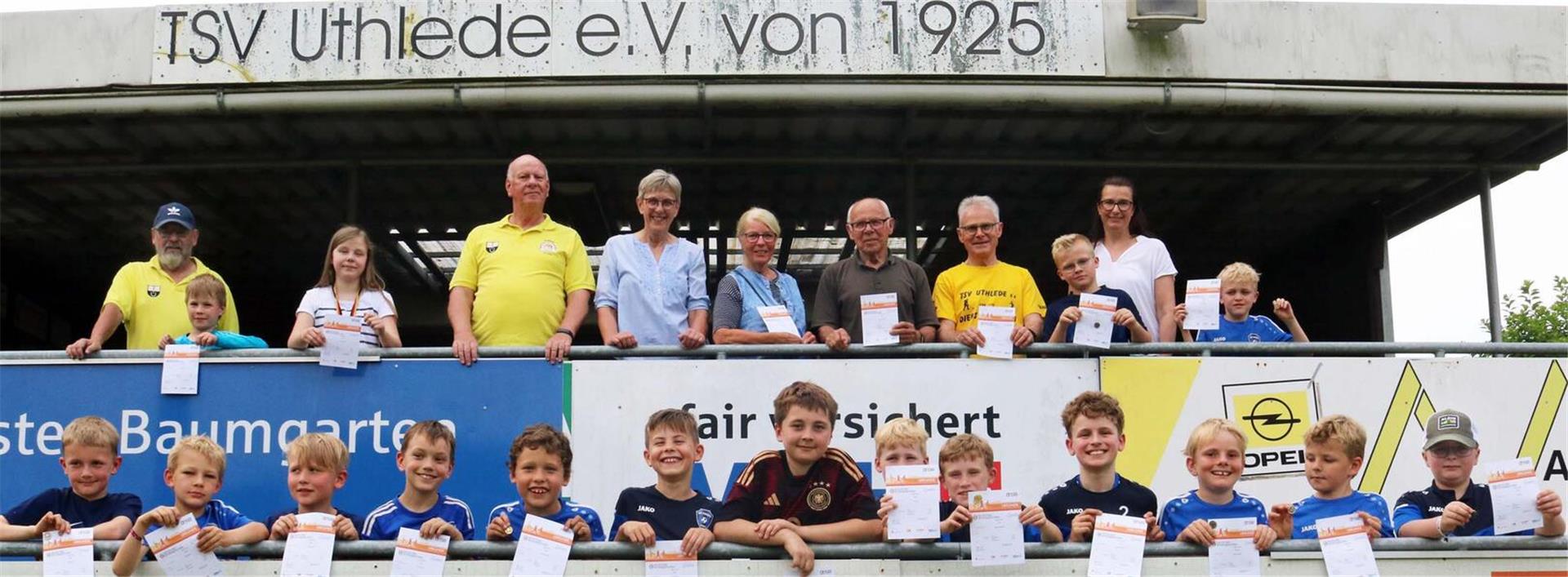 Stolz präsentieren die Absolventen vor dem Vereinsheim des TSV Uthlede ihre Sportabzeichen und Urkunden.