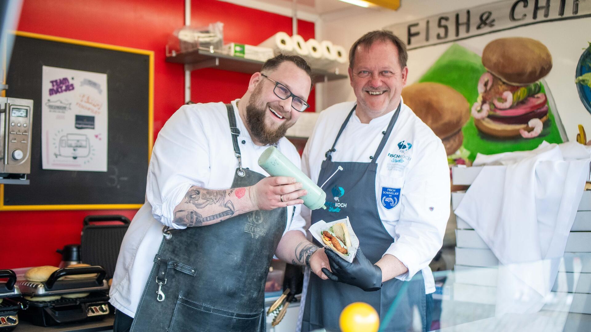 Streetfood mit Fisch: Die Fischexperten vom Fischkochstudio Florian Neumann (links) und Ralf Harms und bereiten ihre kreativen Fischbrötchen zu.