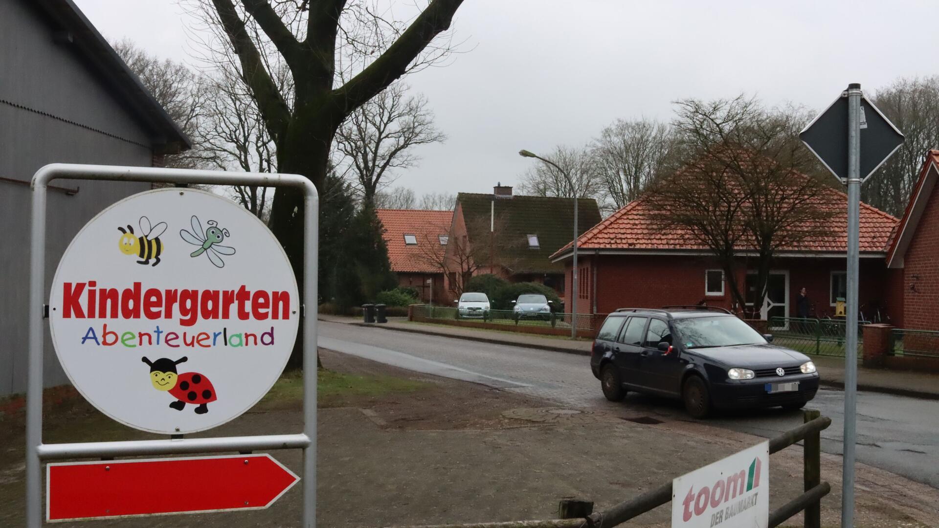 Ein dunkles Auto fährt am Ostertimker Kindergarten vorbei.