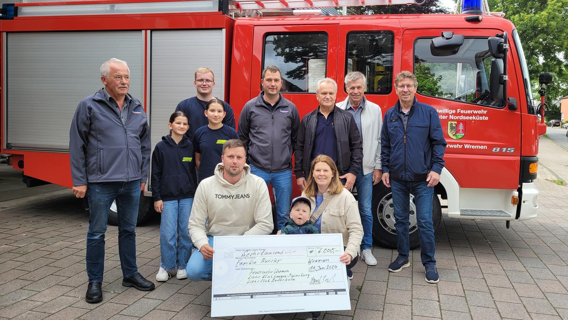 Theo und seine Eltern Berit und Marcel Bursky freuen sich: Die Wremer Feuerwehr spendet der Familie zusammen mit dem Lions Club aus Langen-Pipinsburg und dem Lions Club Bederkesa insgesamt 6000 Euro für den barrierefreien Umbau des Eigenheims.