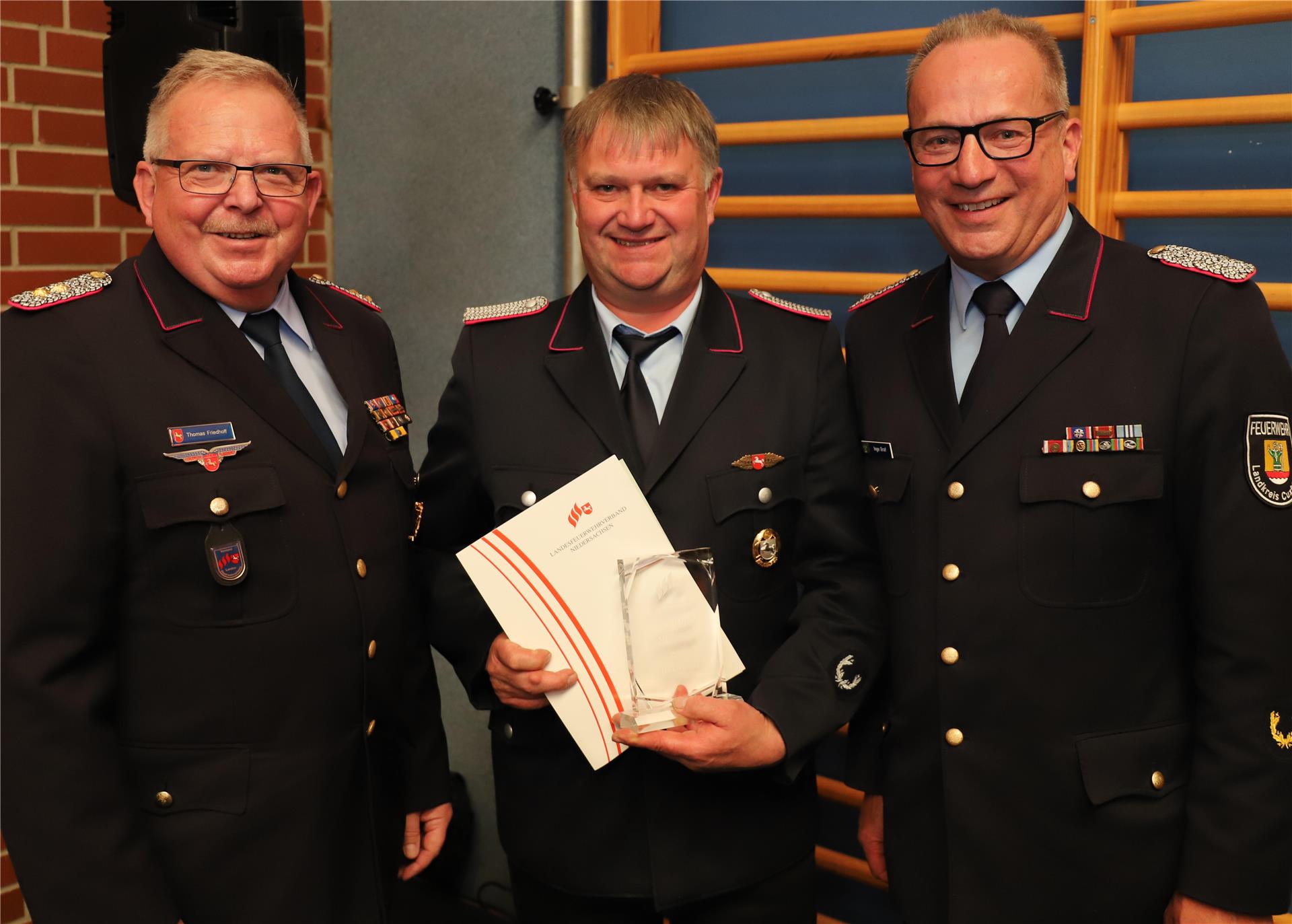 Thomas Friedhoff, Regierungsbrandmeister der Polizeidirektion Oldenburg (links), und Ingo Graf, Abschnittsbrandmeister Cuxhaven-Oste Land Hadeln (rechts), gratulierten der Abbensether Wehr nicht nur zum 100-jährigen Jubiläum, sondern nahmen auch Ehrungen vor.