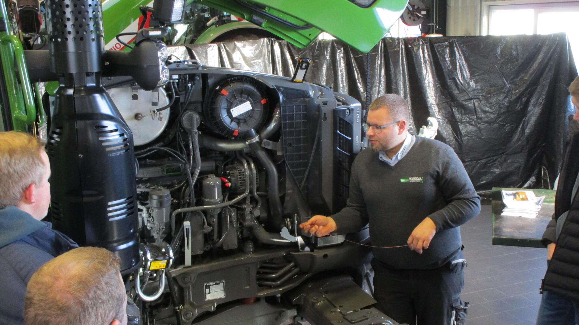 Tobias Meyer erklärt den Auszubildenden Aufbau, Funktionsweise und Wartungsarbeiten an einer Common-Rail-Einspritzanlage am Fendt 724 Vario.