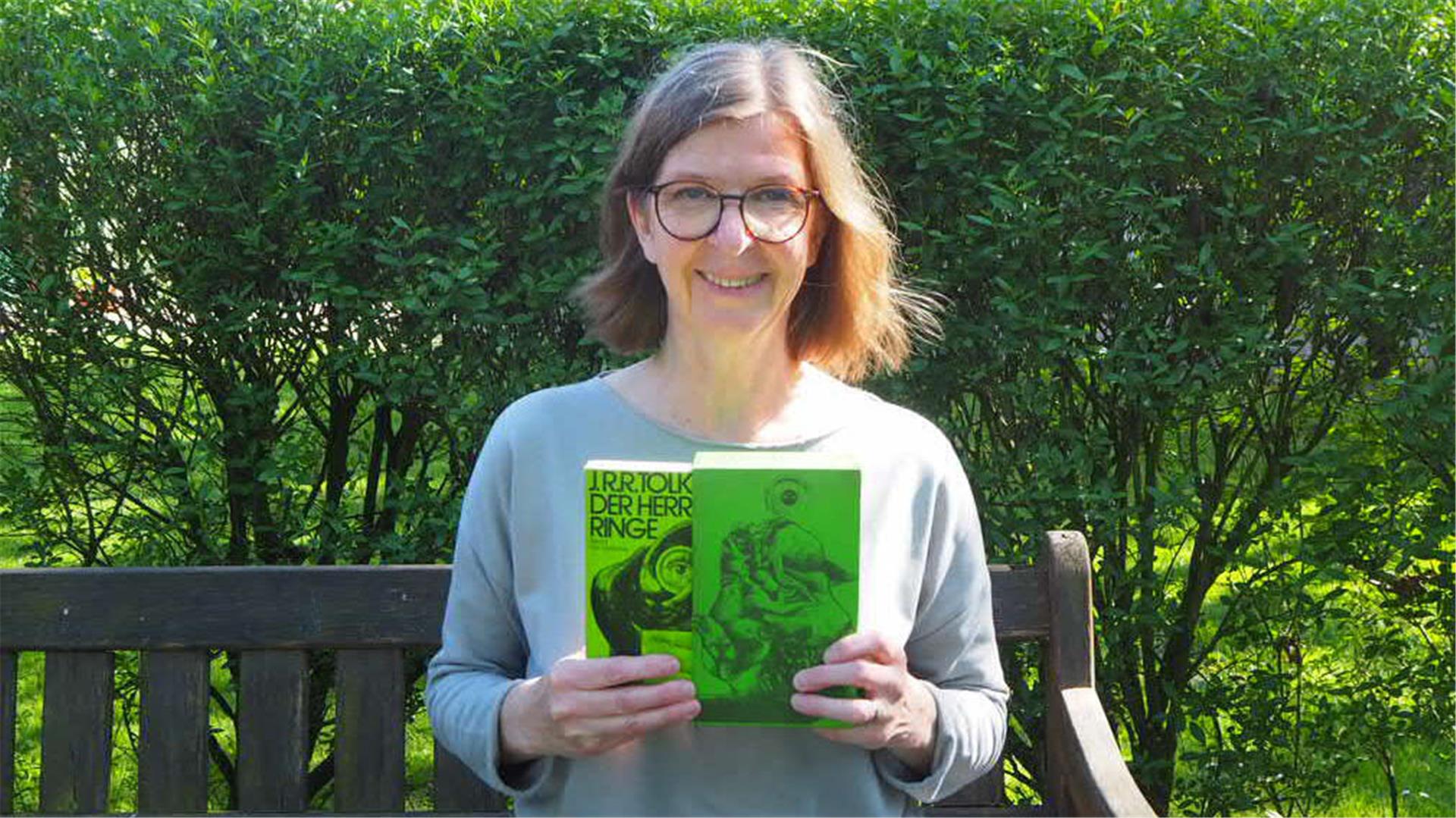 Frau auf einer Bank mit Büchern in der Hand