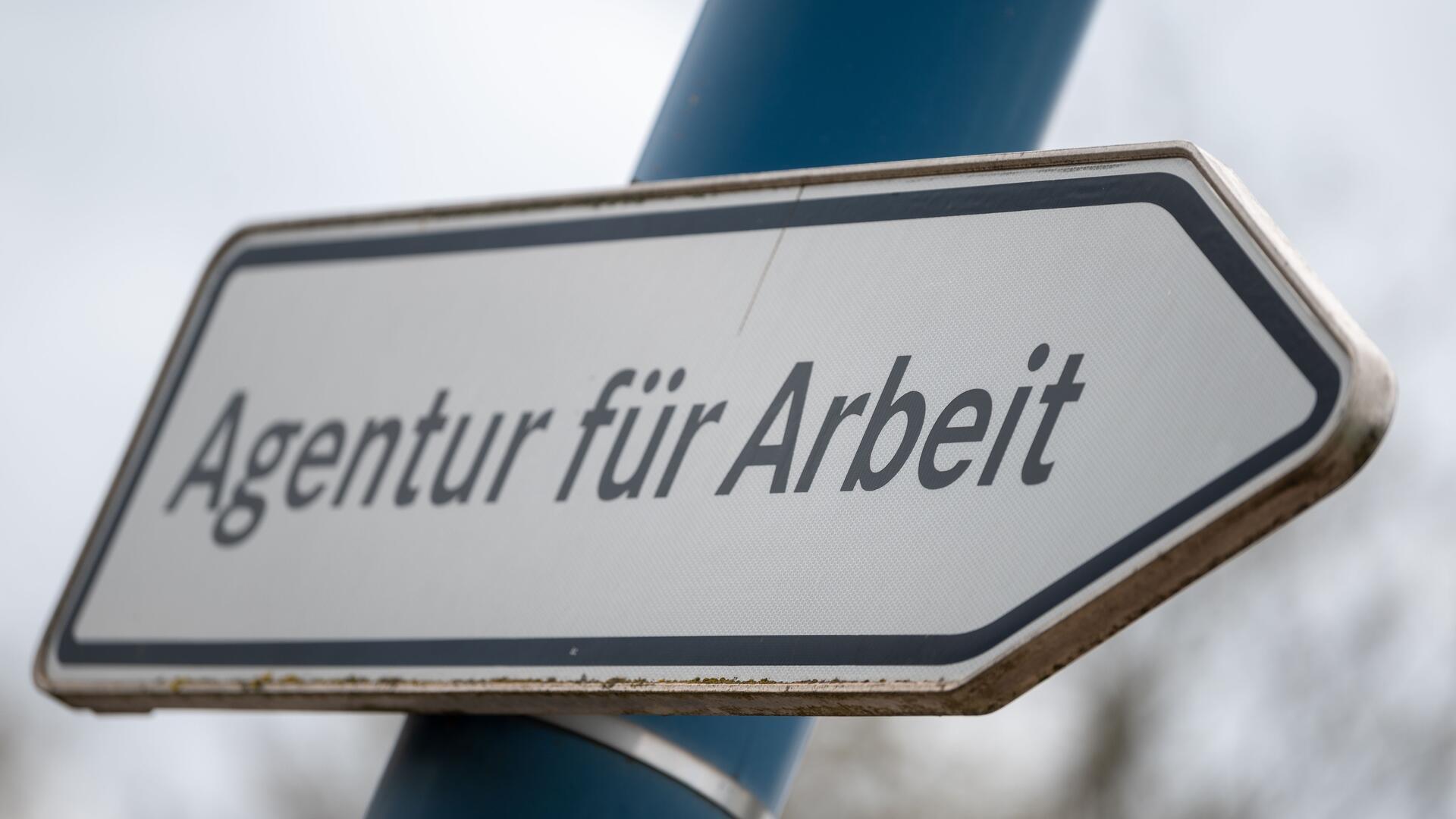 Ein weißes Schild mit der Aufschrift Agentur für Arbeit.