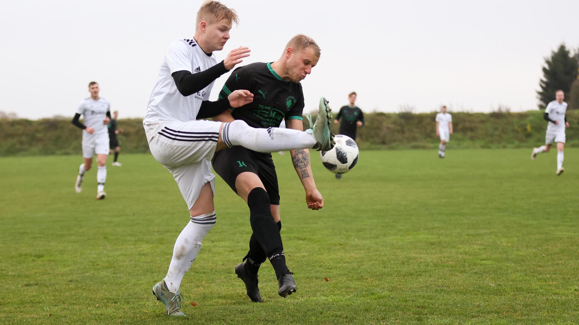 Zwei Männer kämpfen um einen Fußball.