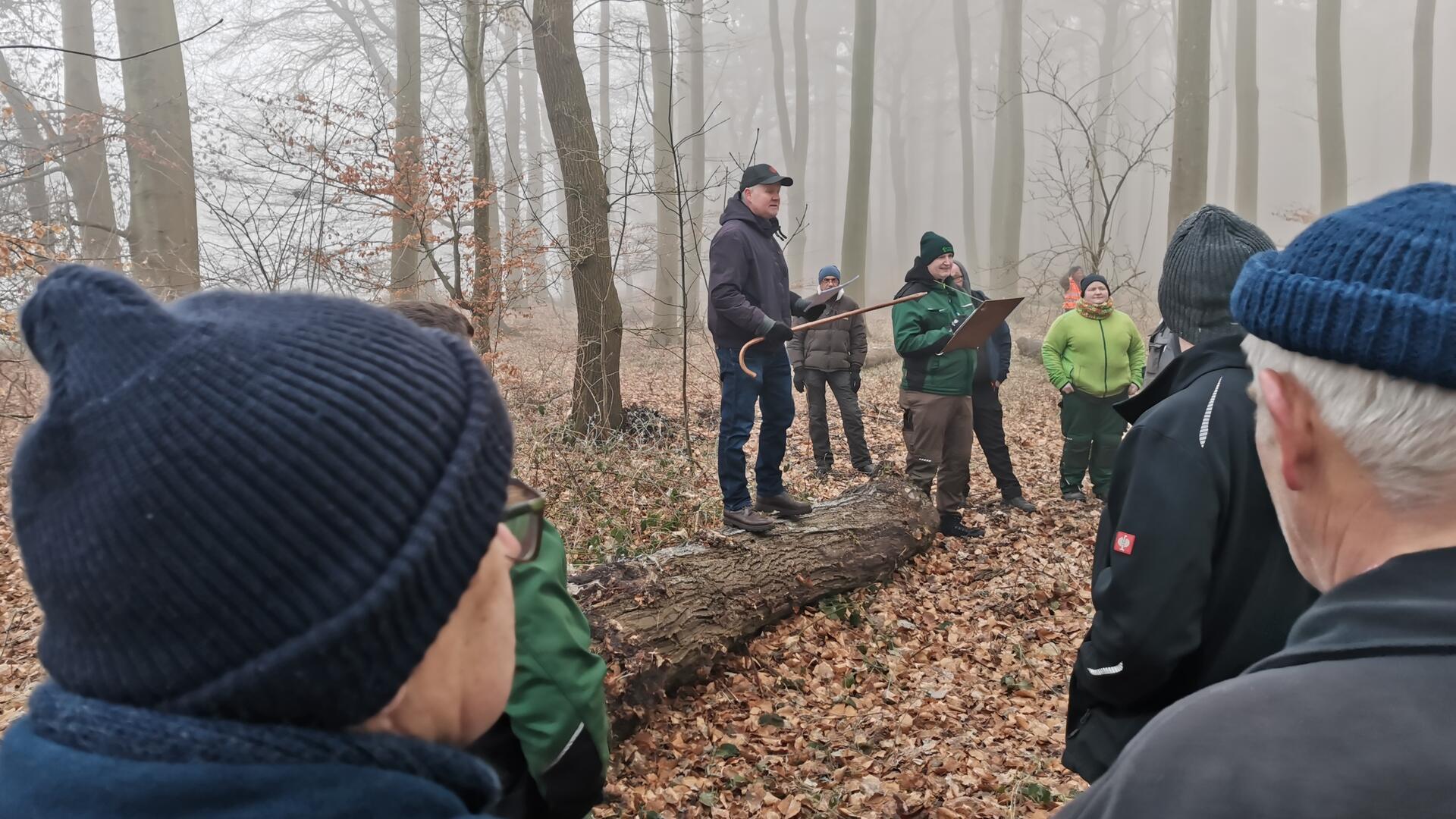 Uwe Lilienthal auf einem Baumstamm bei der Holzauktion in Holßel