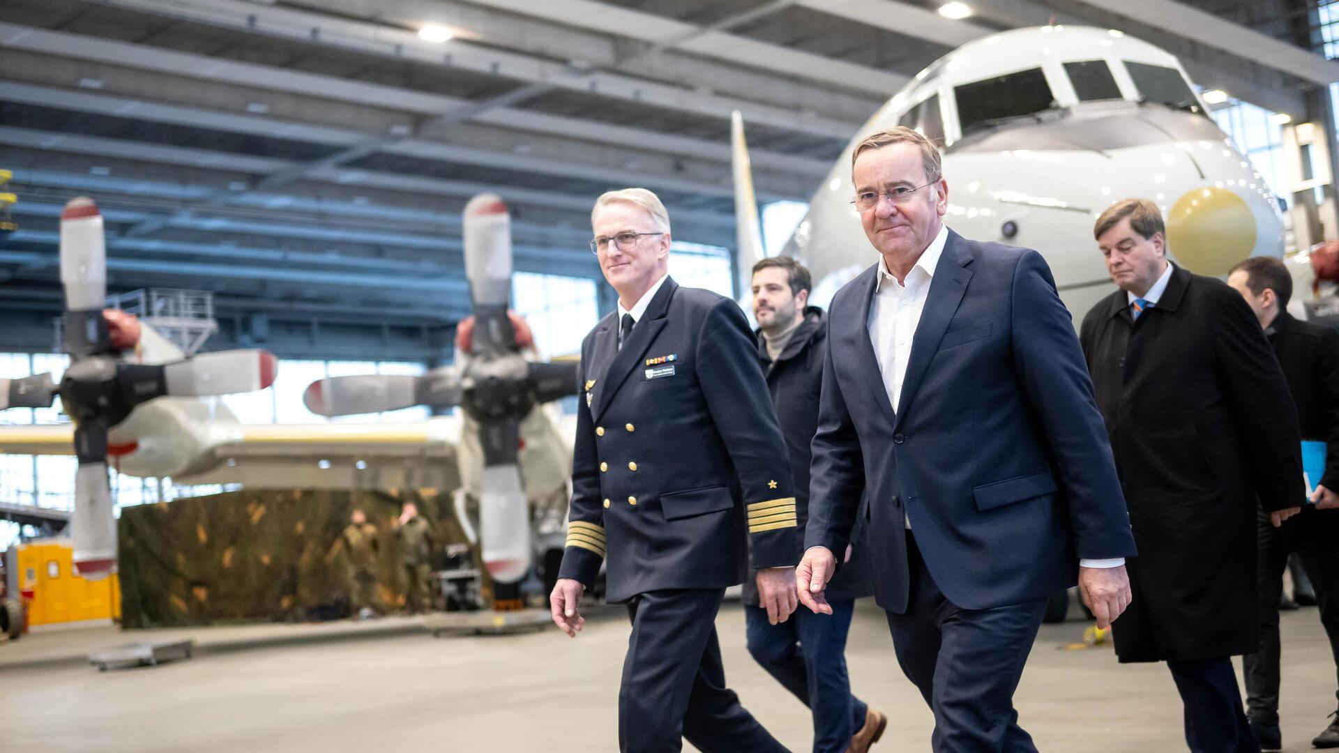 Verteidigungsminister Boris Pistorius (SPD) beim Rundgang durch eine Flugzeughalle auf dem Stützpunkt der Nordholzer Marineflieger. An seiner Seite der Kommandeur des Marinefliegerkommandos, Kapitän zur See Broder Nielsen (links).