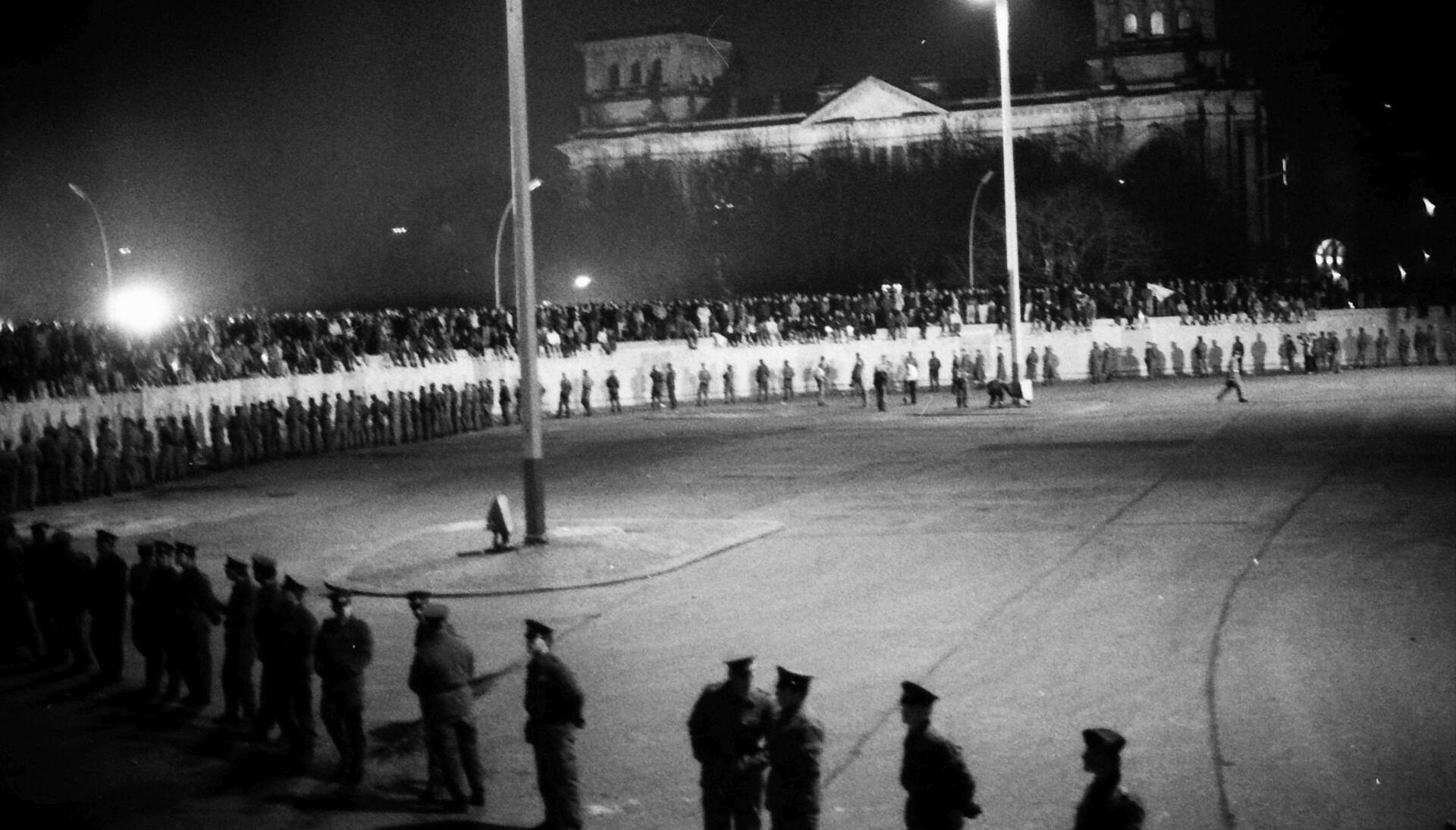 Viele klettern auf der Grenzbefestigung herum. Beobachter befürchten, dass es zu Zusammenstößen mit DDR-Volkspolizisten kommen könnte.