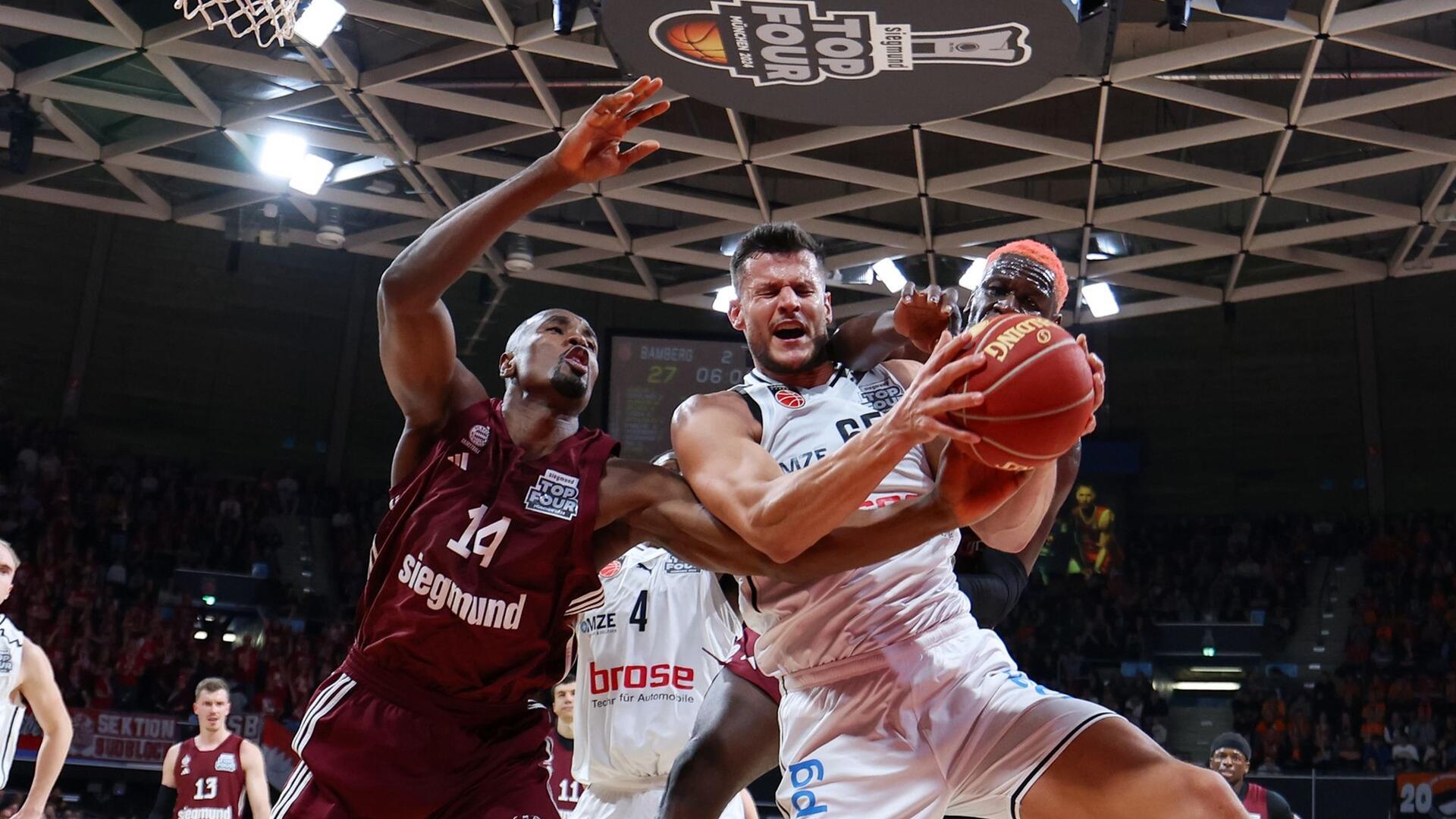 Voller Körpereinsatz: Der Bamberger Filip Stanic (M) greift sich vor den Münchenern Serge Ibaka (l) und Isaac Bonga den Ball. Am Ende konnte trotzdem Bayern München das Spiel für sich entscheiden - und steht damit im Finale der Basketball-Bundesliga.