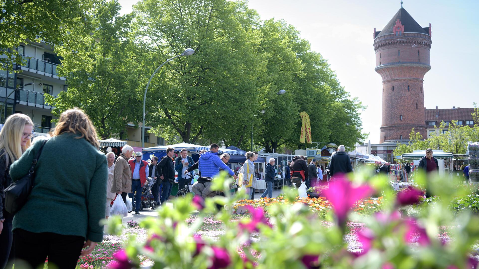 Blütenfestbesucher und Blumen auf dem Konrad-Adenauer-Platz in Bremerhaven-Geestemünde in Sichtweite des Geestemünder Wasserturms.