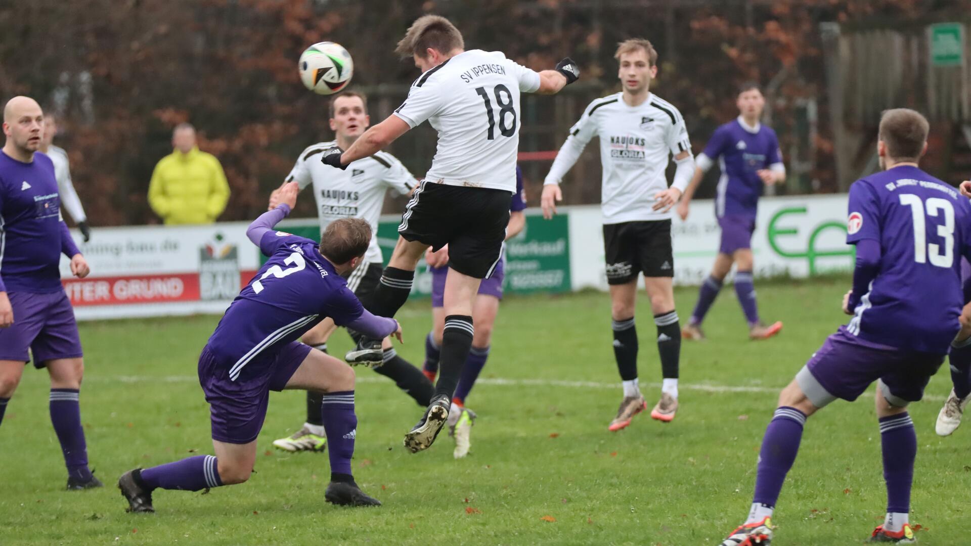 Drei Männer in schwarzweißen Trikots, einer springt hoch zu einem Ball, vier Männer in lila Trikots schauen zu.