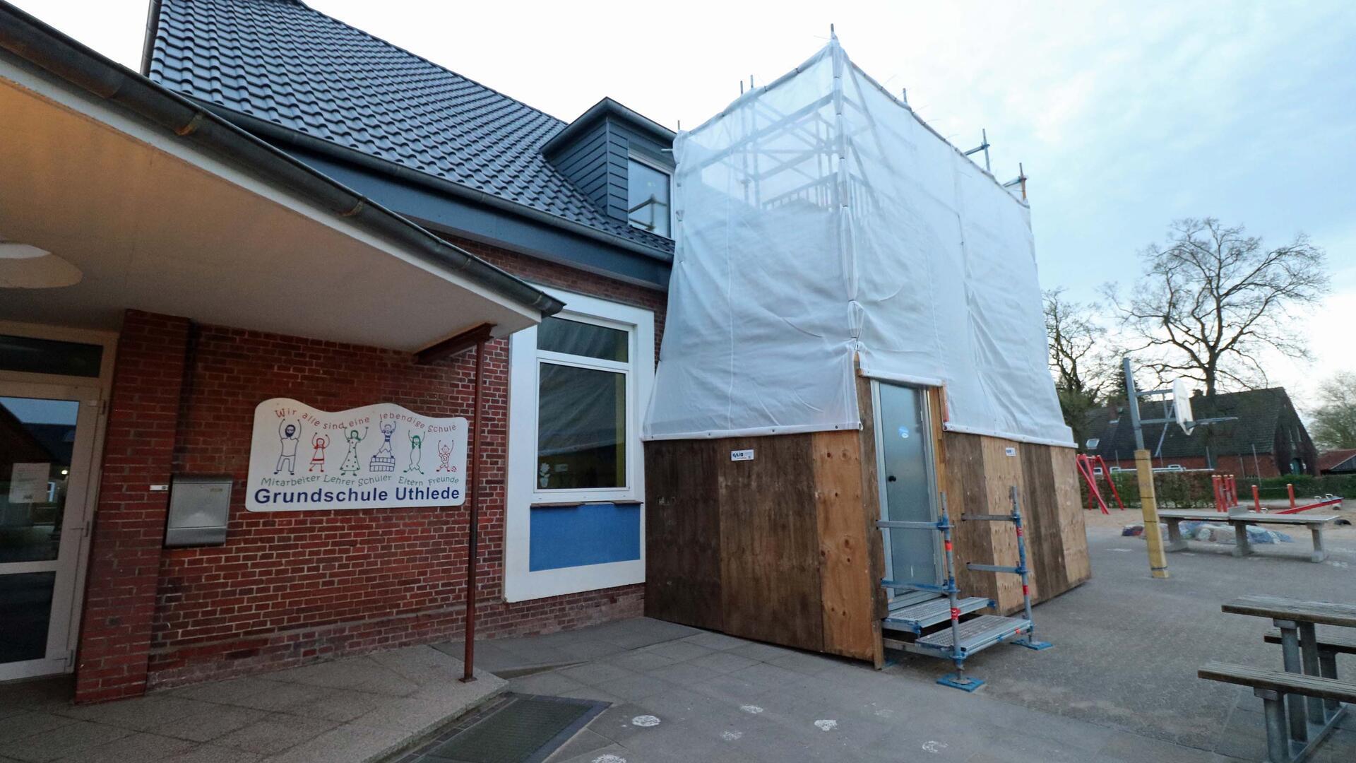 Eingangsbereich der Grundschule Uthlede mit einem Baugerüst, das mit Holz und Planen verkleidet ist