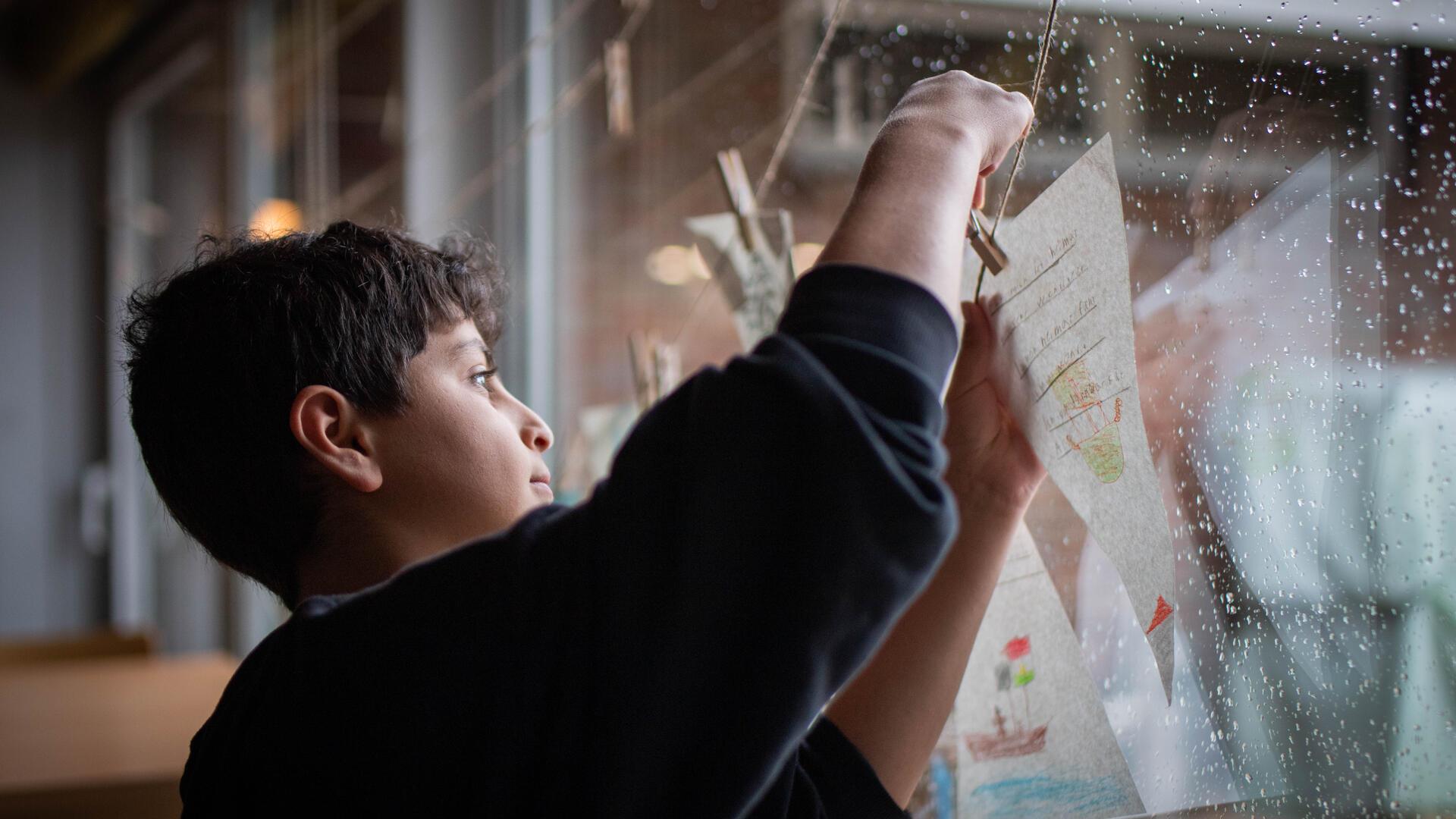 Was macht dich glücklich? Gemeinsam hängen die Bremerhavener Schüler, hier Asaad (12), ihre Wimpel neben die der Seeleute.