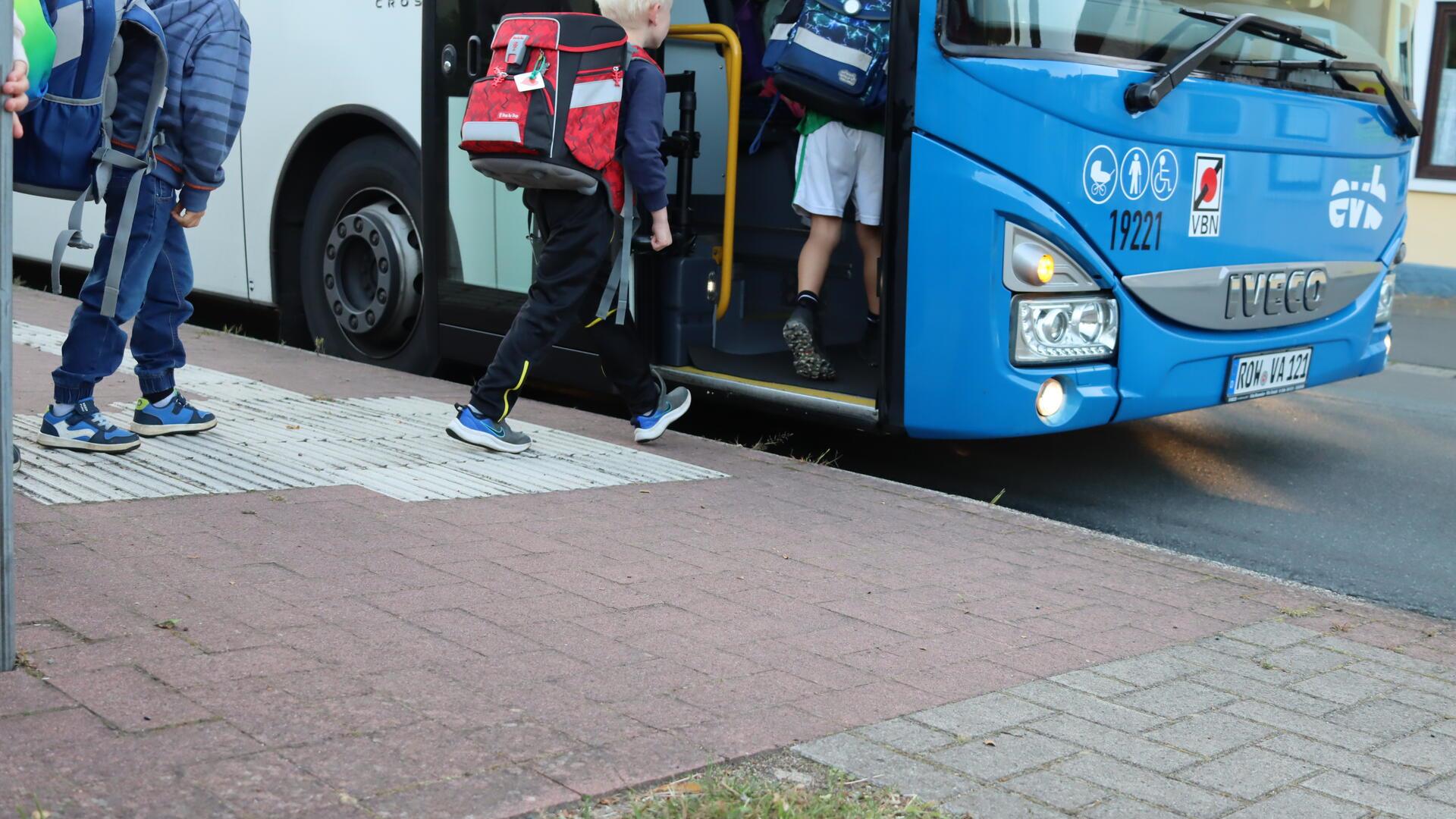 Kinder steigen in einen Bus.