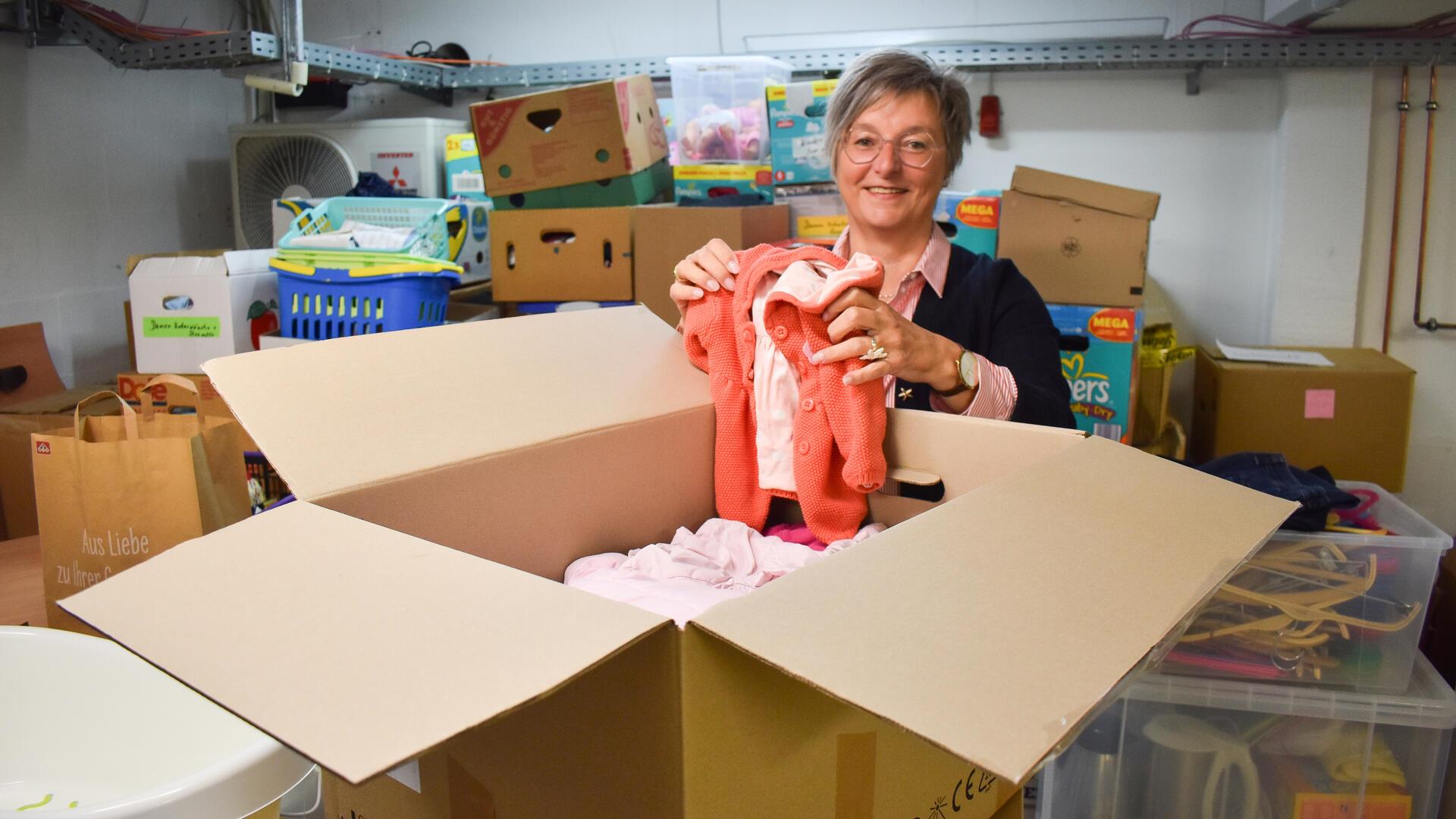 Eine Frau hält eine Babyjacke in der Hand 