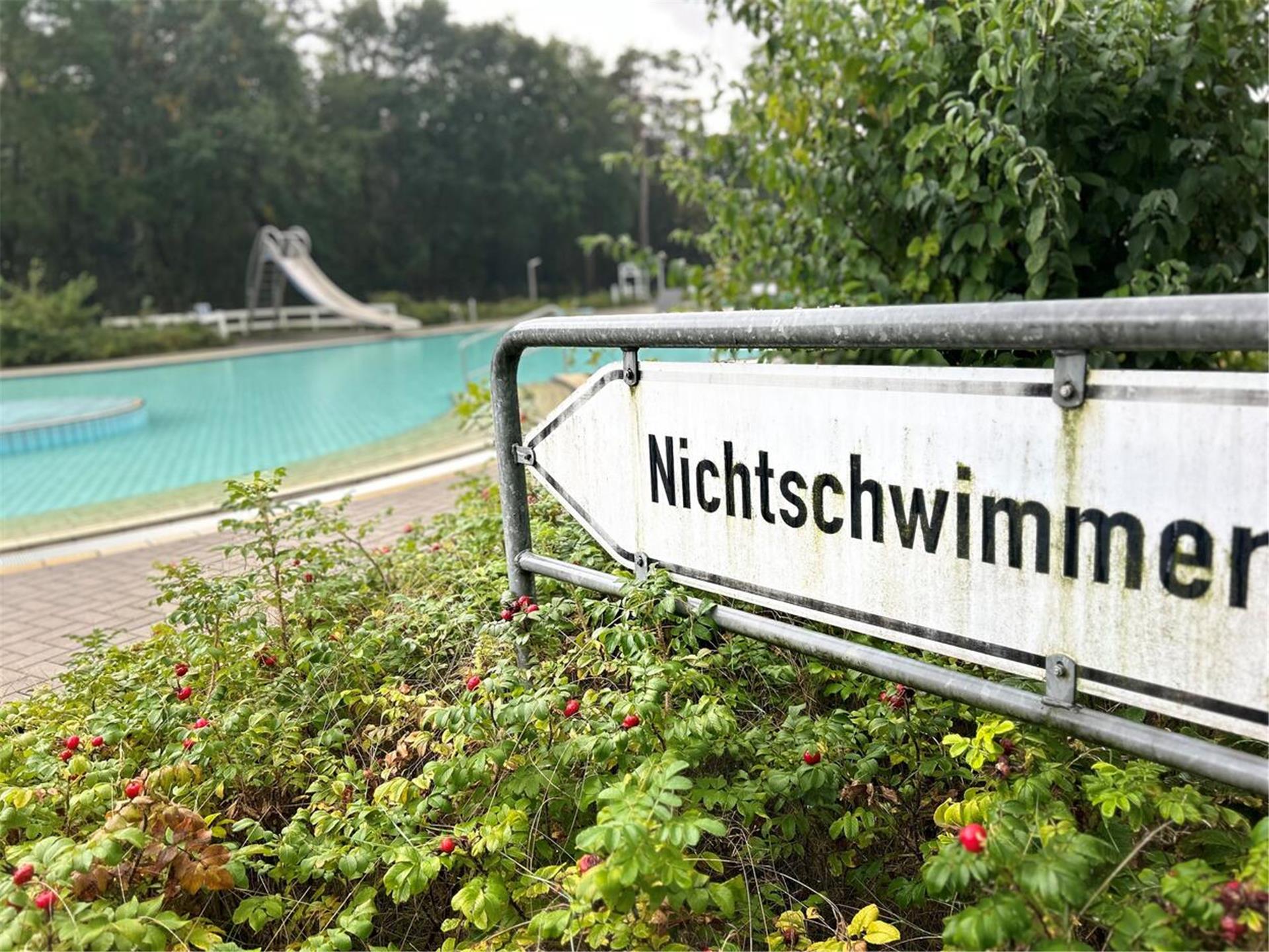 Ein Schild mit der Aufschrift "Nichtschwimmer" steht in einem Schwimmbad. 