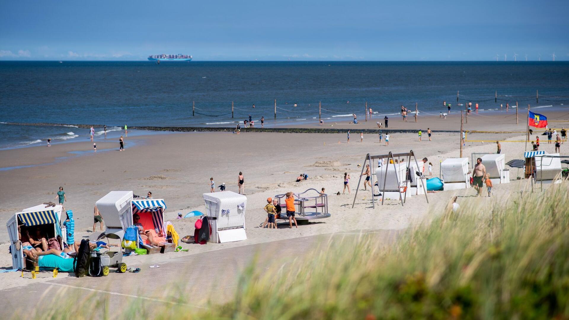 Zahlreiche Touristen sitzen bei sonnigem Wetter in Strandkörben am Strand der Insel Wangerooge.