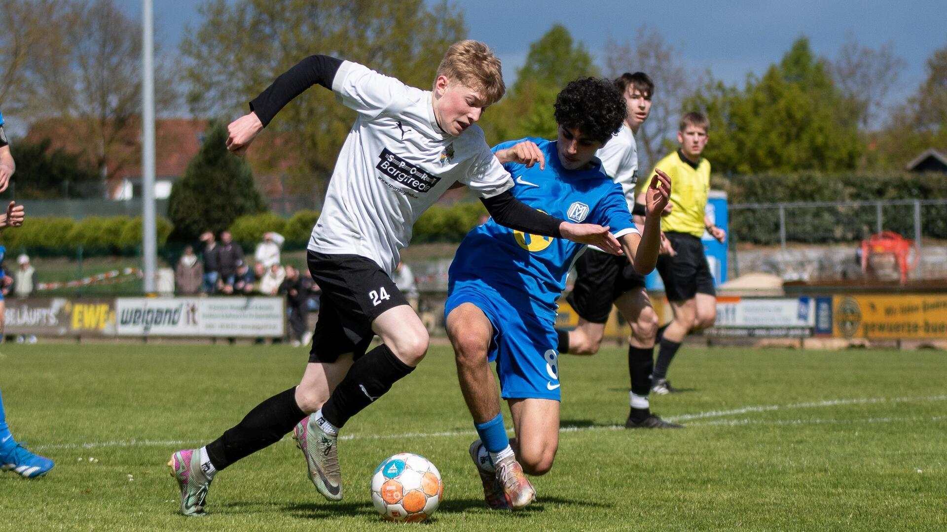 Zwei junge Männer kämpfen um einen Ball.