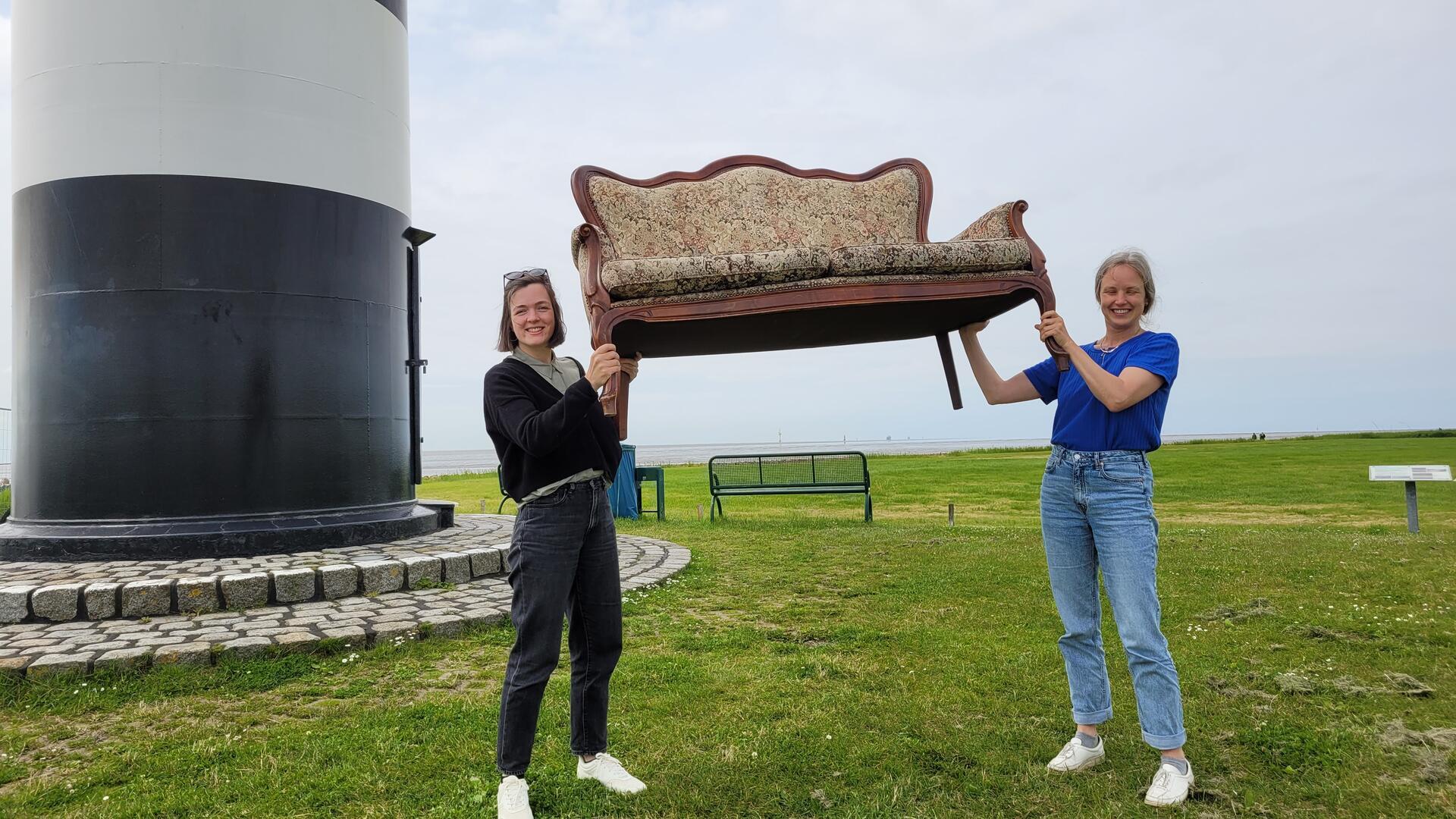 Zwei starke Frauen. Das neue alte Kultursofa der Gemeinde Wurster Nordseeküste stemmen Saskia Stöwing (links) und Ulla Puckhaber mit links.